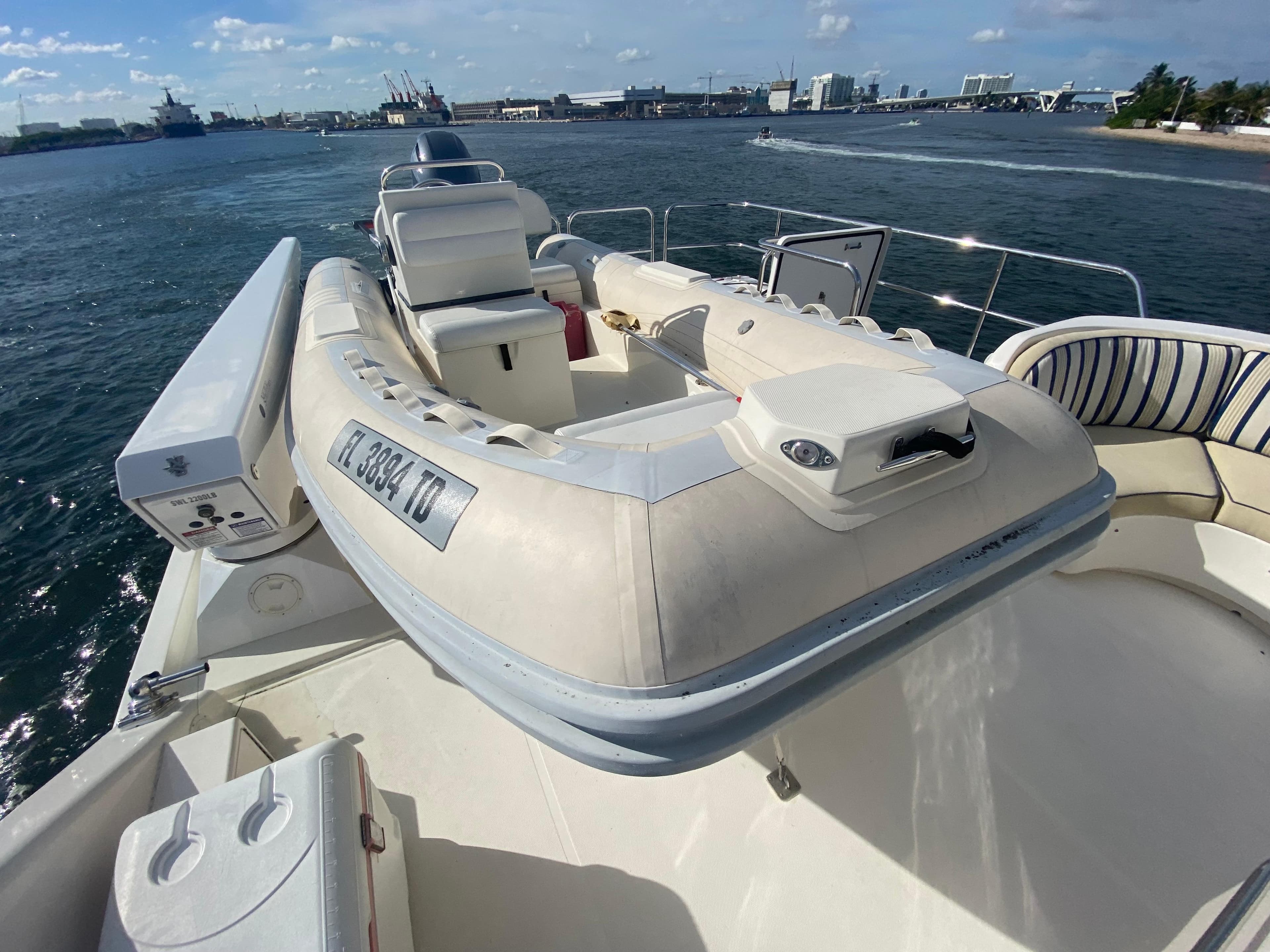 2005 Pacific Mariner 85 yacht with inflatable boat on deck, docked by the waterfront.