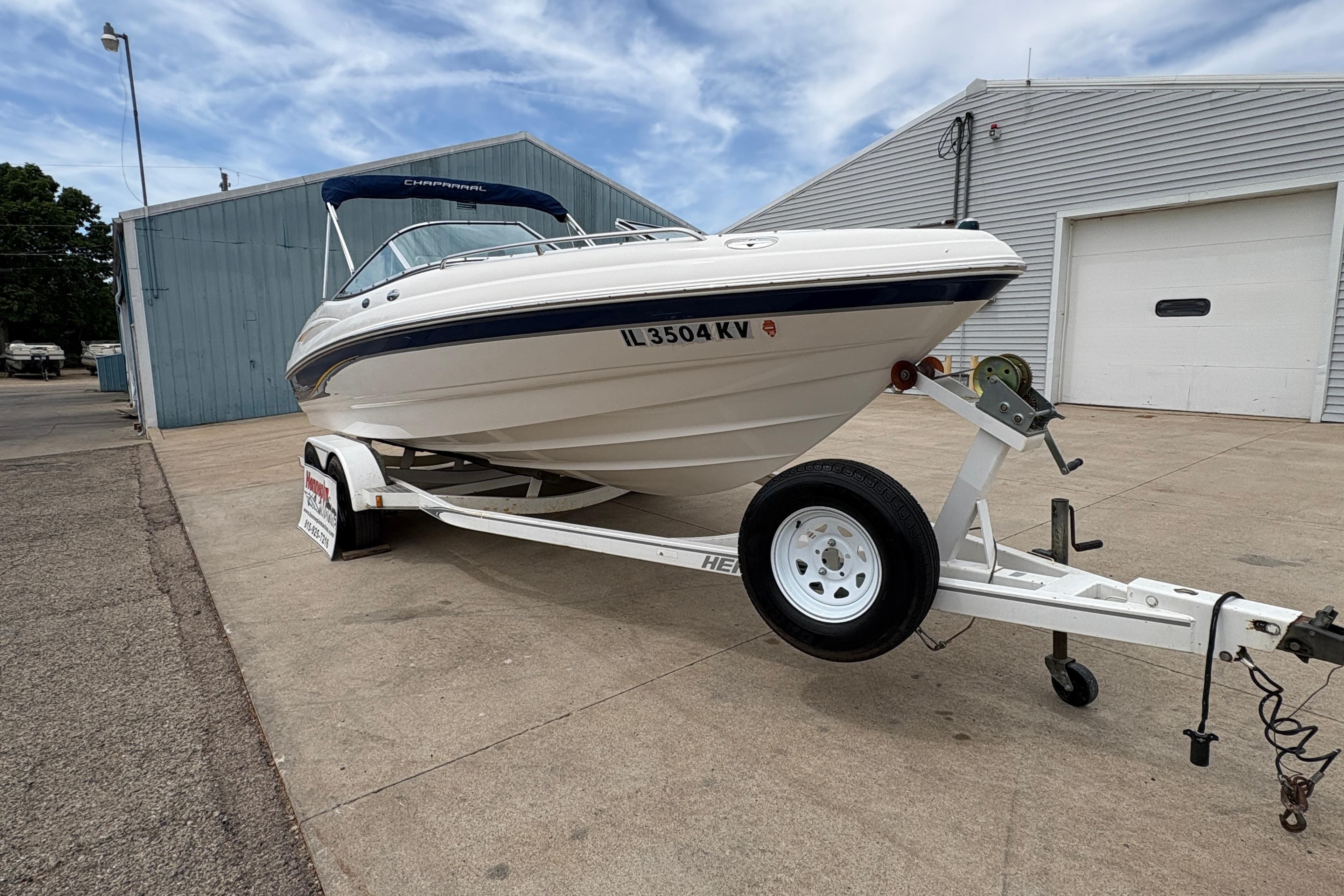 2003 Chaparral 210 SS boat on trailer, parked outside a warehouse.