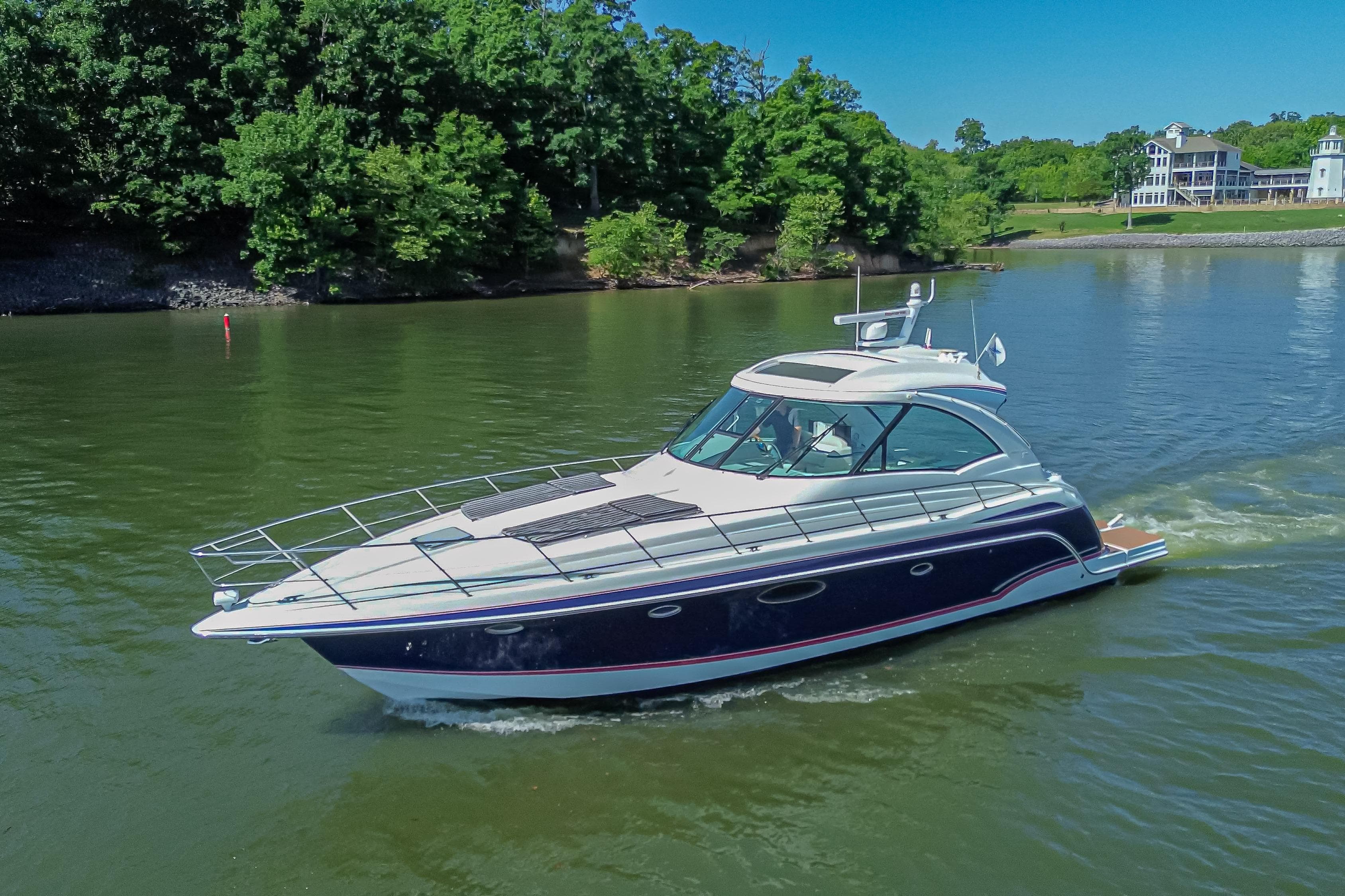 2008 Formula 45 Yacht cruising on a serene lake with lush green surroundings.