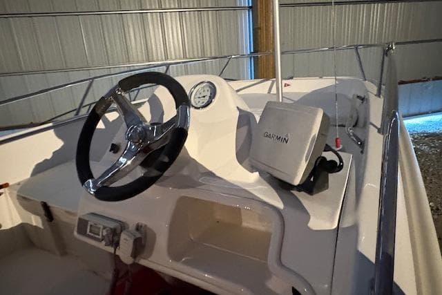 2010 Boston Whaler 150 Super Sport boat interior with steering wheel and Garmin device.