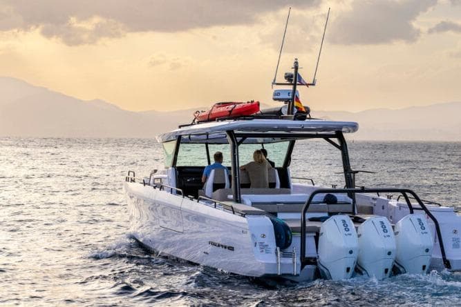 2027 Axopar 45 Cross Top boat cruising on open water at sunset.