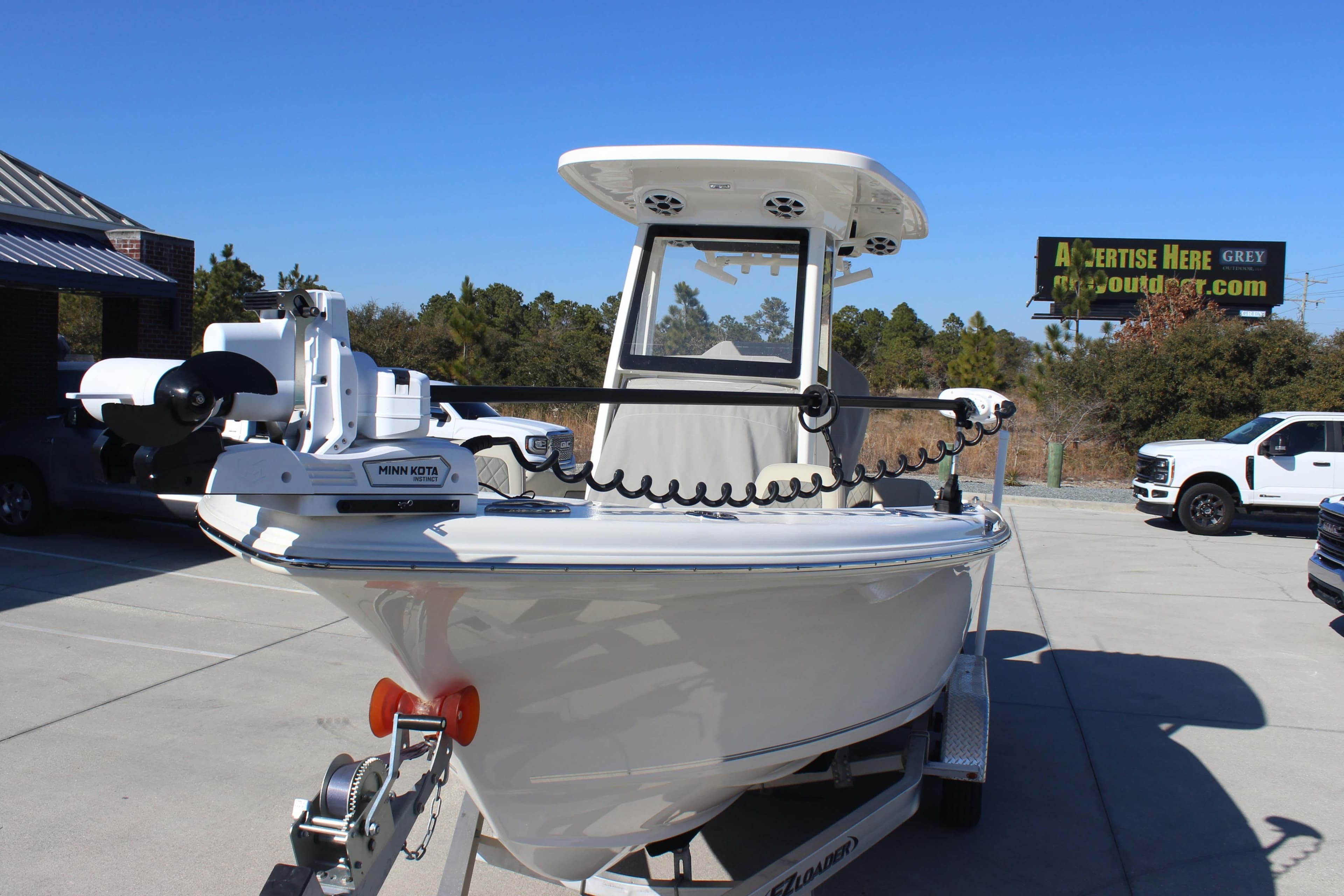 2025 Key West 239 FSR boat on trailer, featuring Minn Kota motor, parked outdoors.
