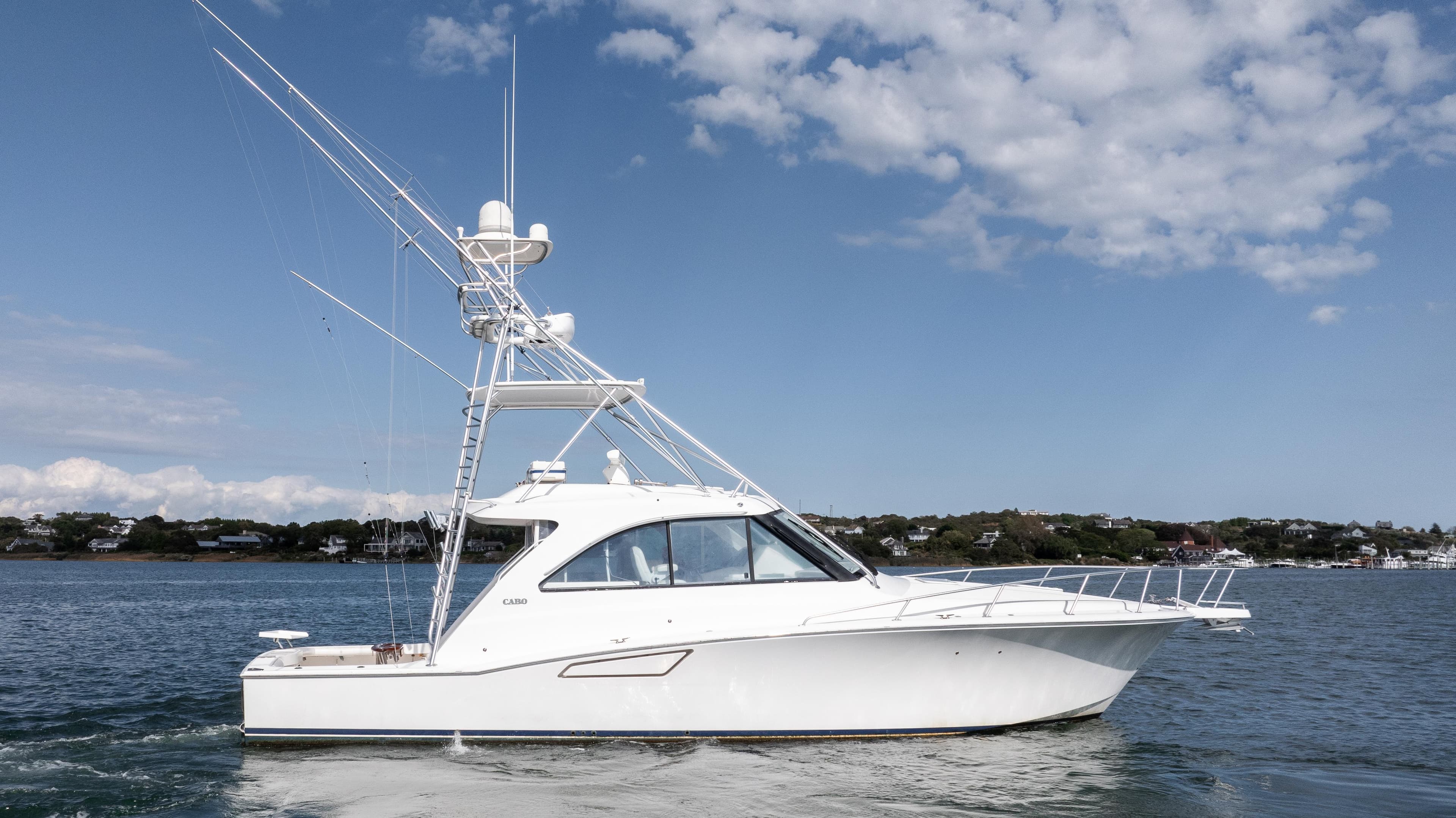 2012 Cabo 44 HTX yacht on calm water under a blue sky.
