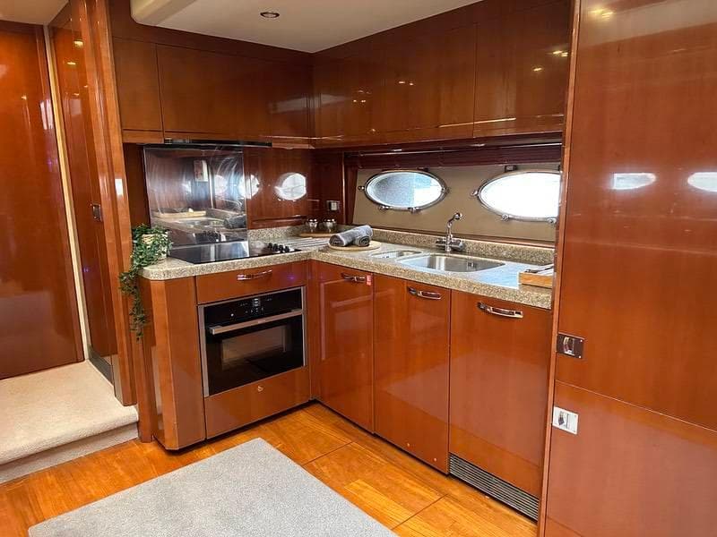 Luxurious kitchen interior of 2007 Princess V70 yacht with wood cabinetry and modern appliances.