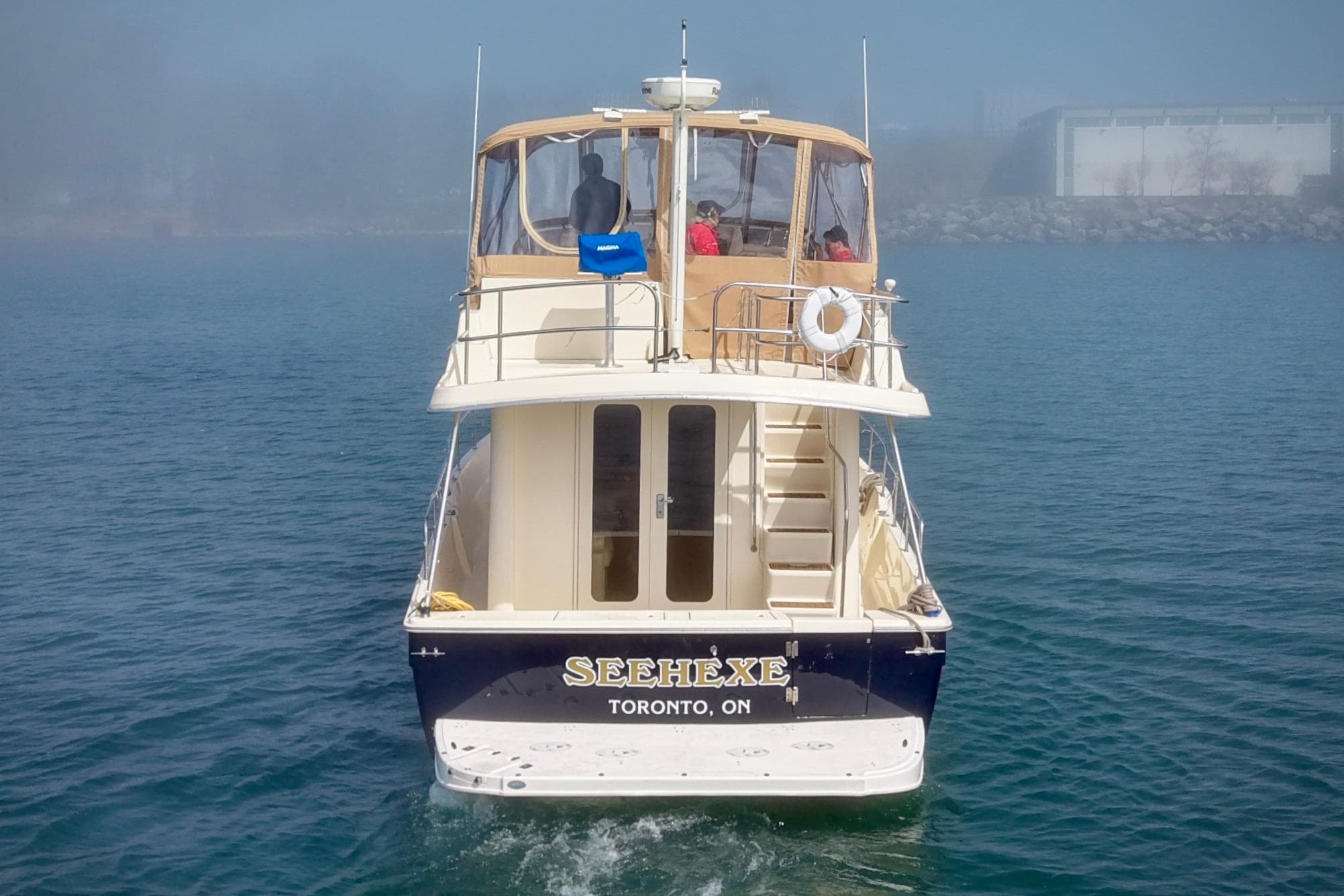 2006 Mainship 34 Trawler on water, rear view, with Toronto registration.