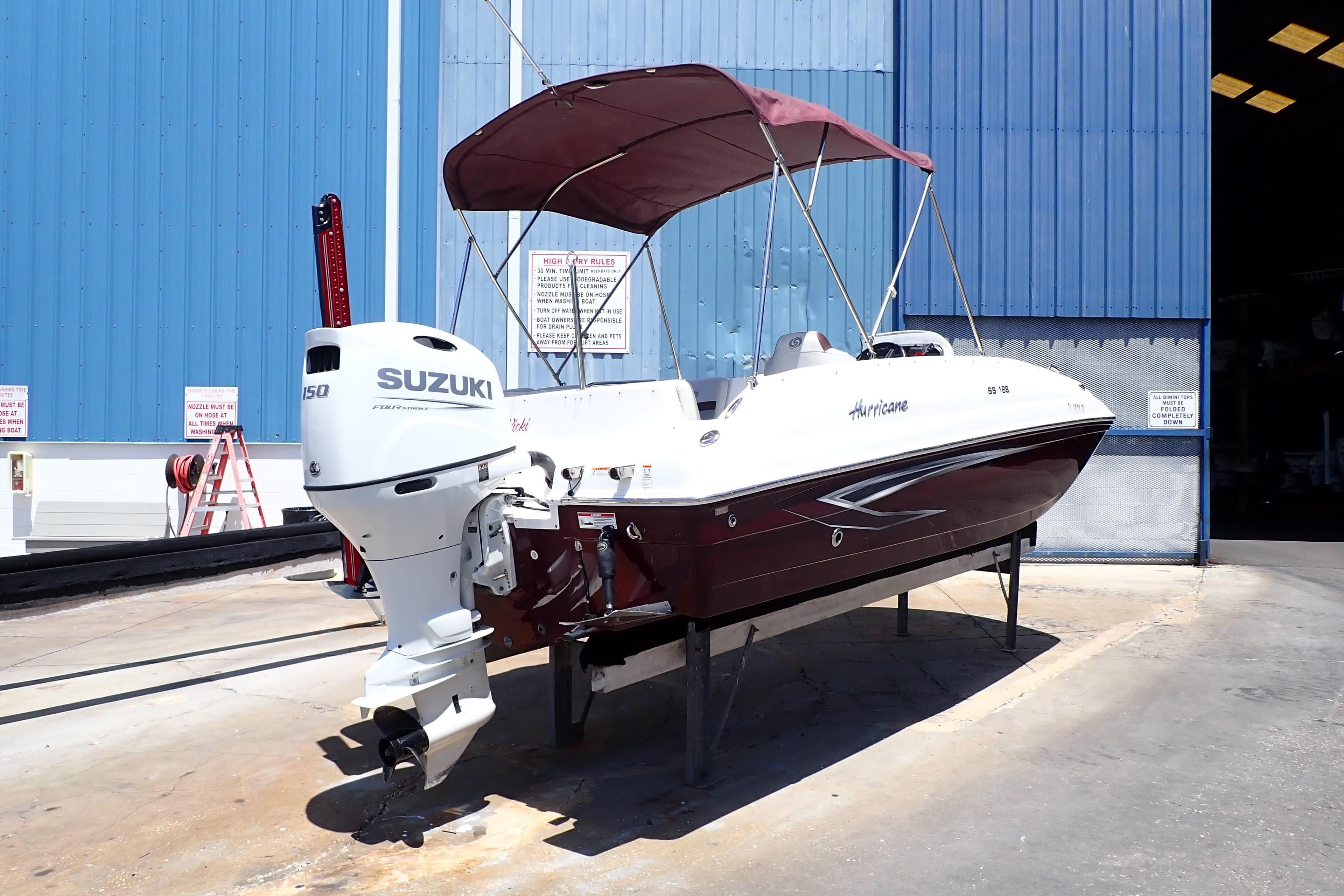2021 Hurricane SunDeck Sport 185 OB boat with Suzuki outboard motor in a marina setting.