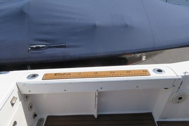 2006 Sea Hunt Triton 260 boat deck with ruler and covered seating area.