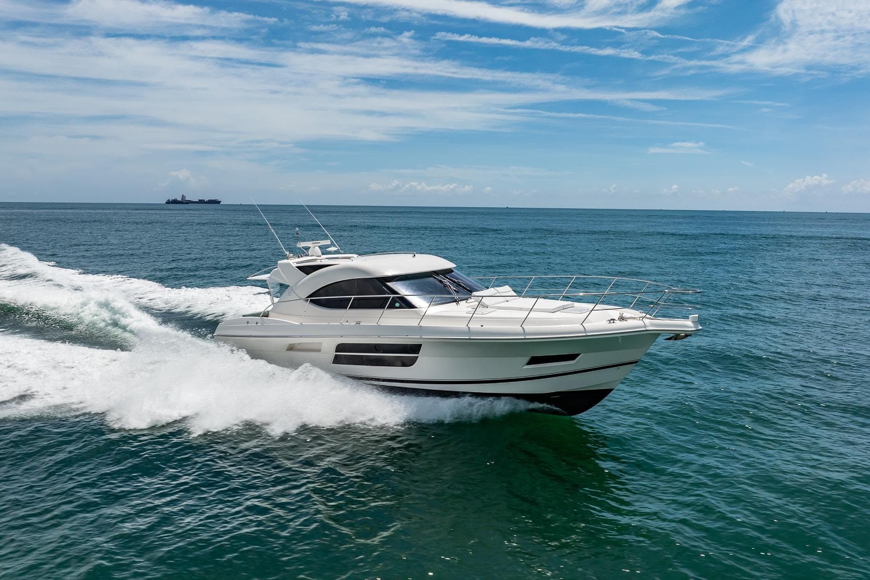 2016 Riviera 5000 Sport Yacht cruising on open sea under clear blue sky.