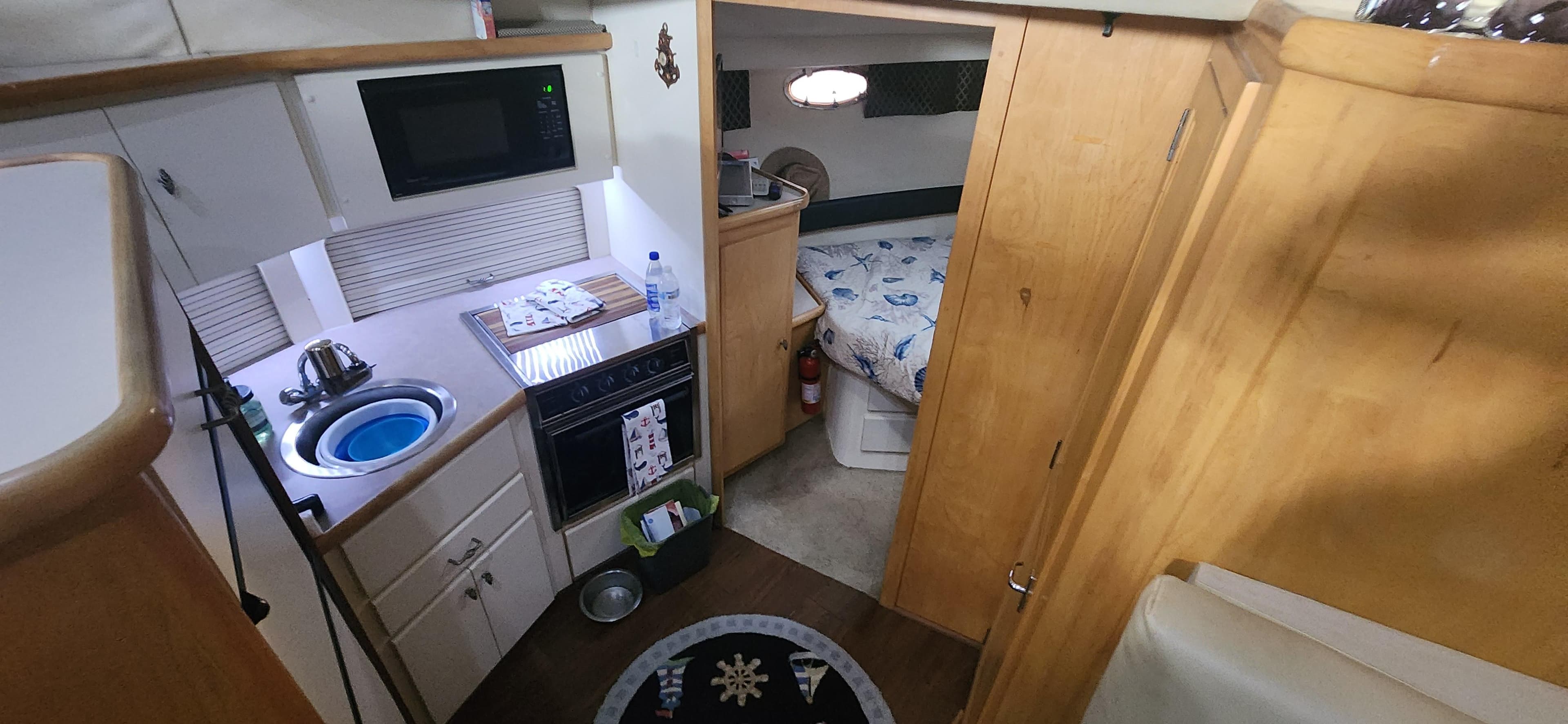 Interior of 1996 Carver 400 Cockpit Motor Yacht with kitchen and cozy bedroom.