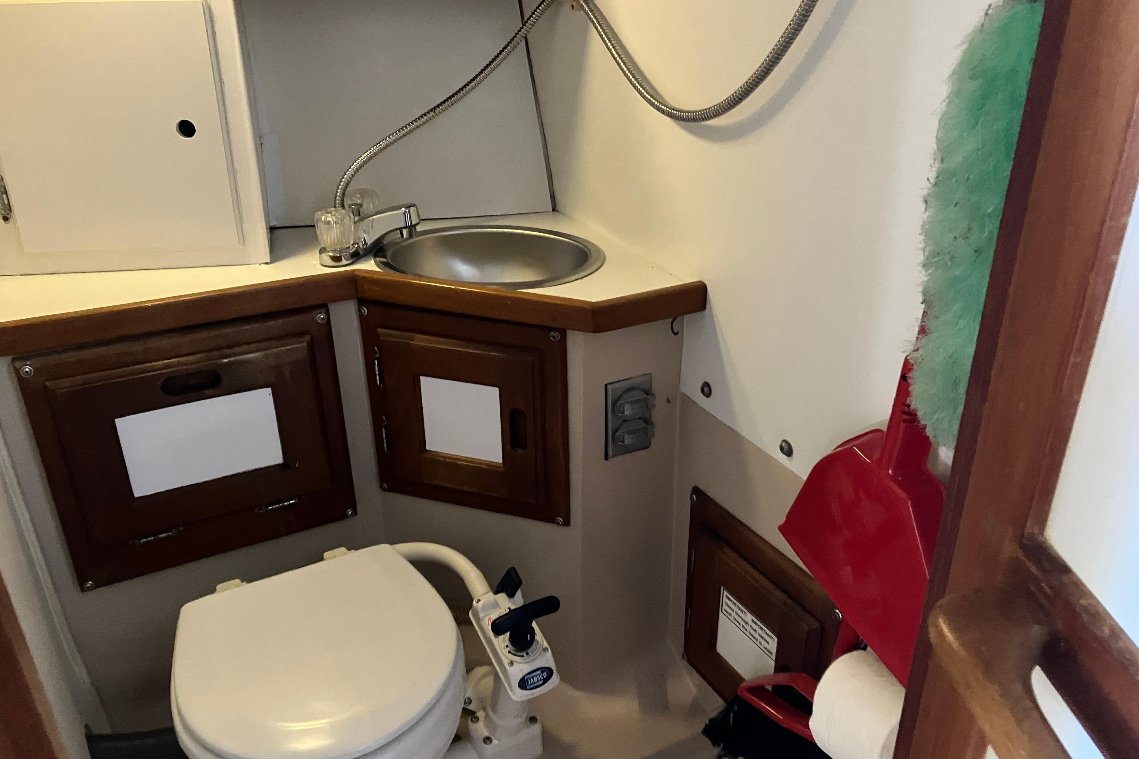 1985 Catalina 30 boat bathroom with sink, toilet, and storage cabinets.