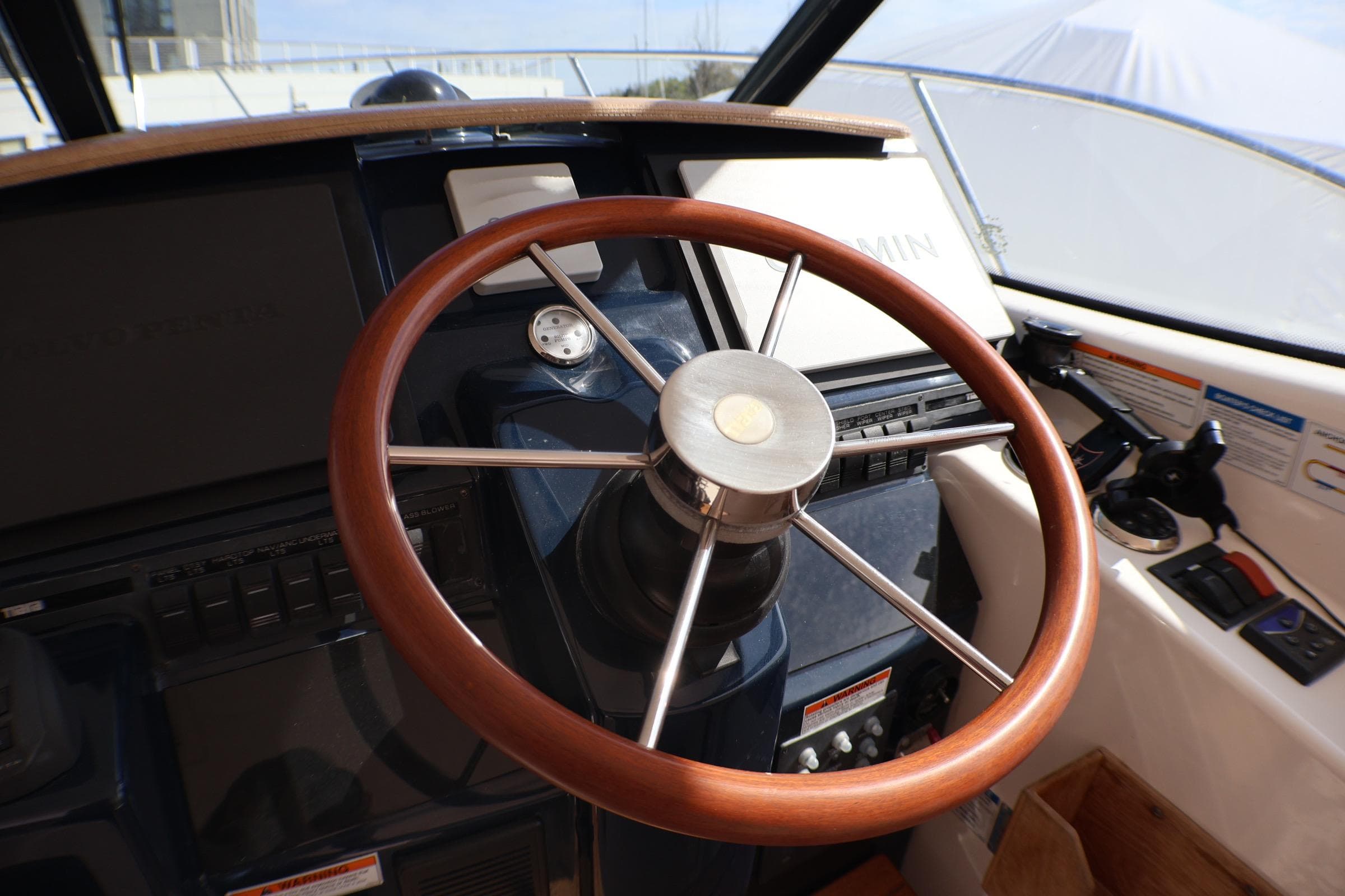 Steering wheel of 2009 Tiara Yachts 3500 Sovran, featuring a sleek wooden design.