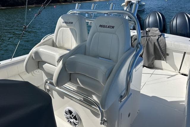 2015 Regulator 34 boat with dual white captain's chairs on deck.