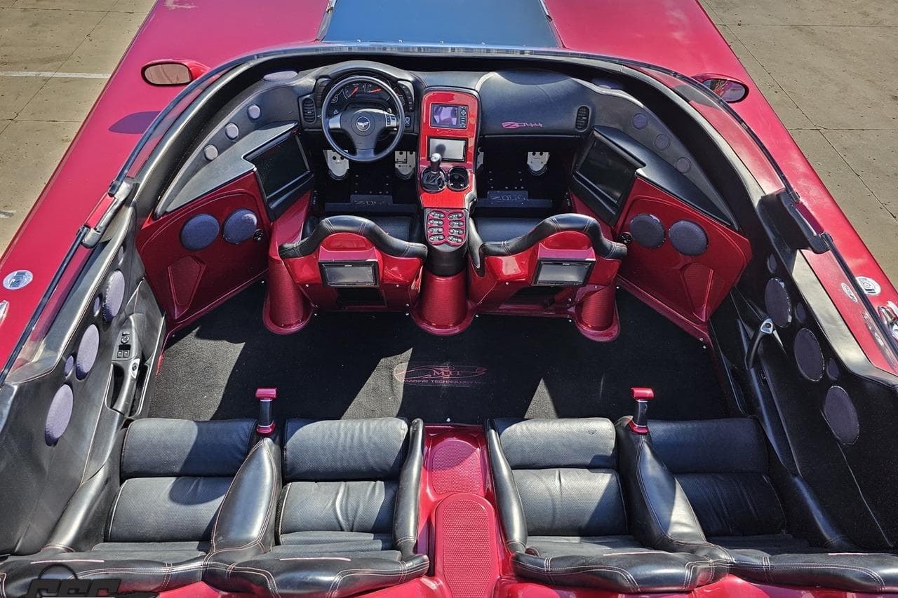 Interior of a 2010 MTI 44 Corvette, featuring red and black leather seats and advanced dashboard.