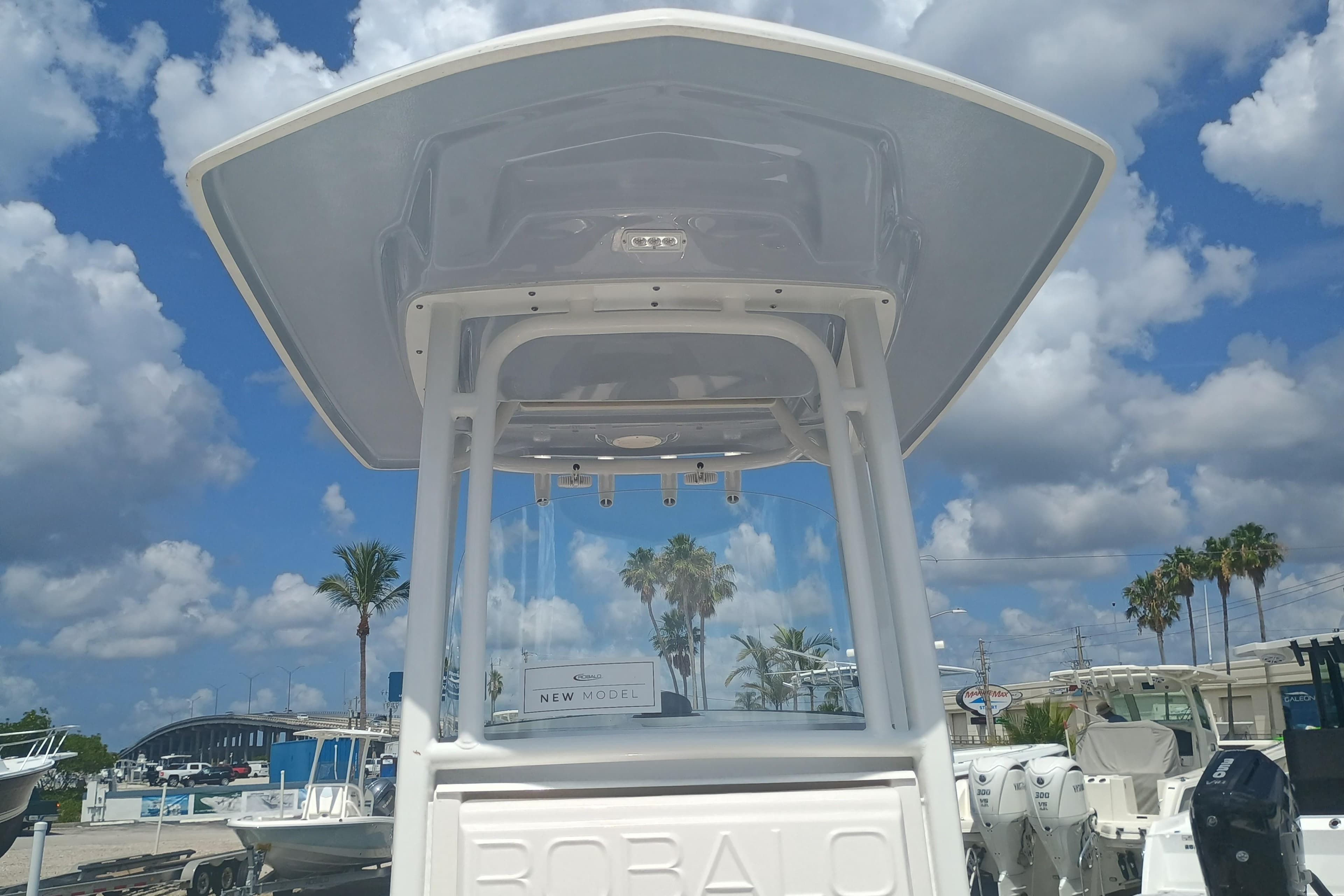 2025 Robalo R230 Center Console boat under a clear blue sky with clouds.