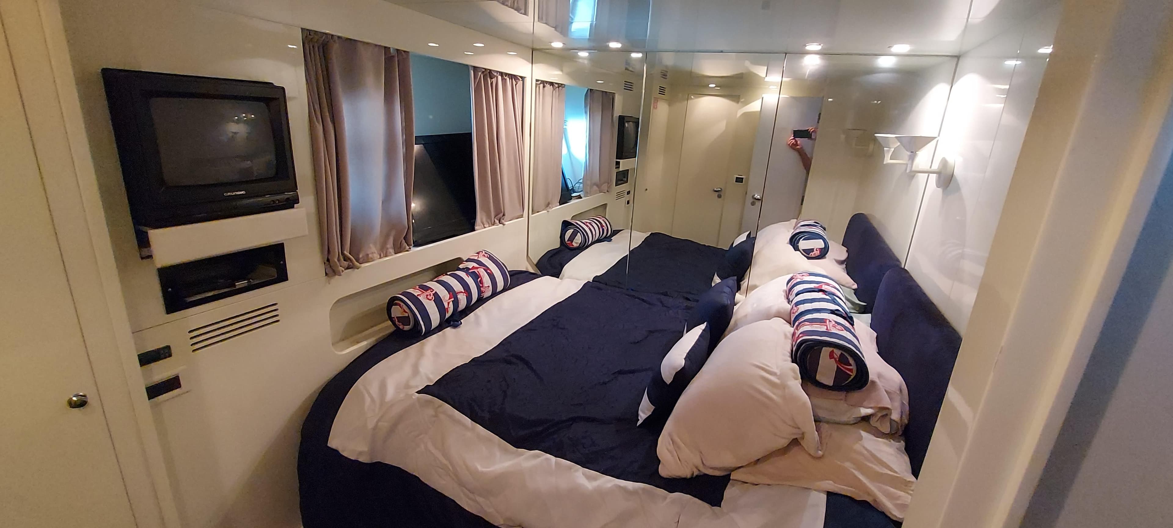 Luxurious bedroom interior of 1990 Versilcraft Challenger Motor Yacht with cozy bedding and TV.