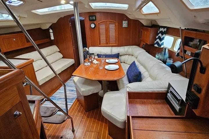 Luxurious interior of a 2002 Hunter 420 sailboat with cozy seating and dining area.