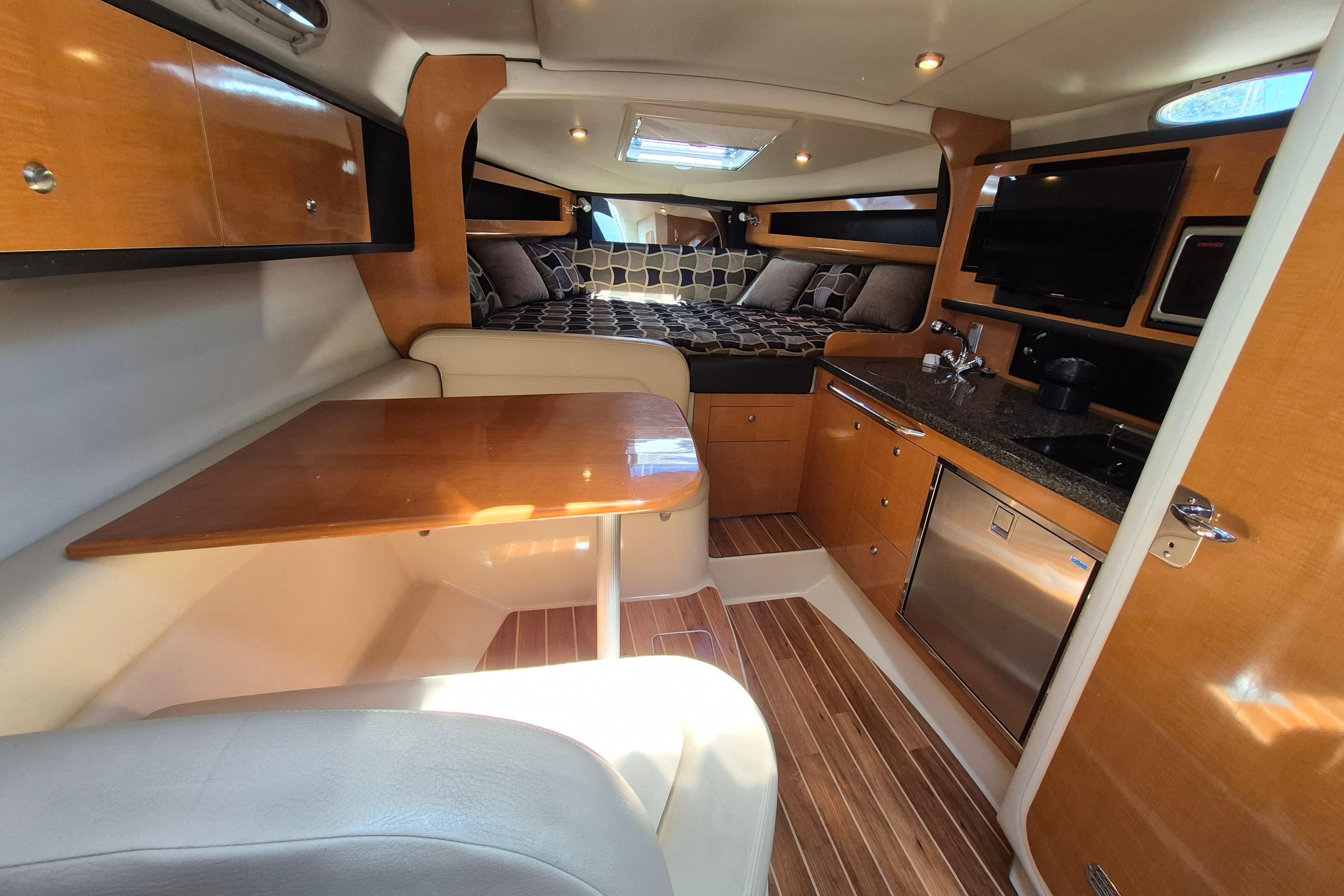 Interior of 2008 Chaparral Signature 280 boat with kitchenette and cozy sleeping area.