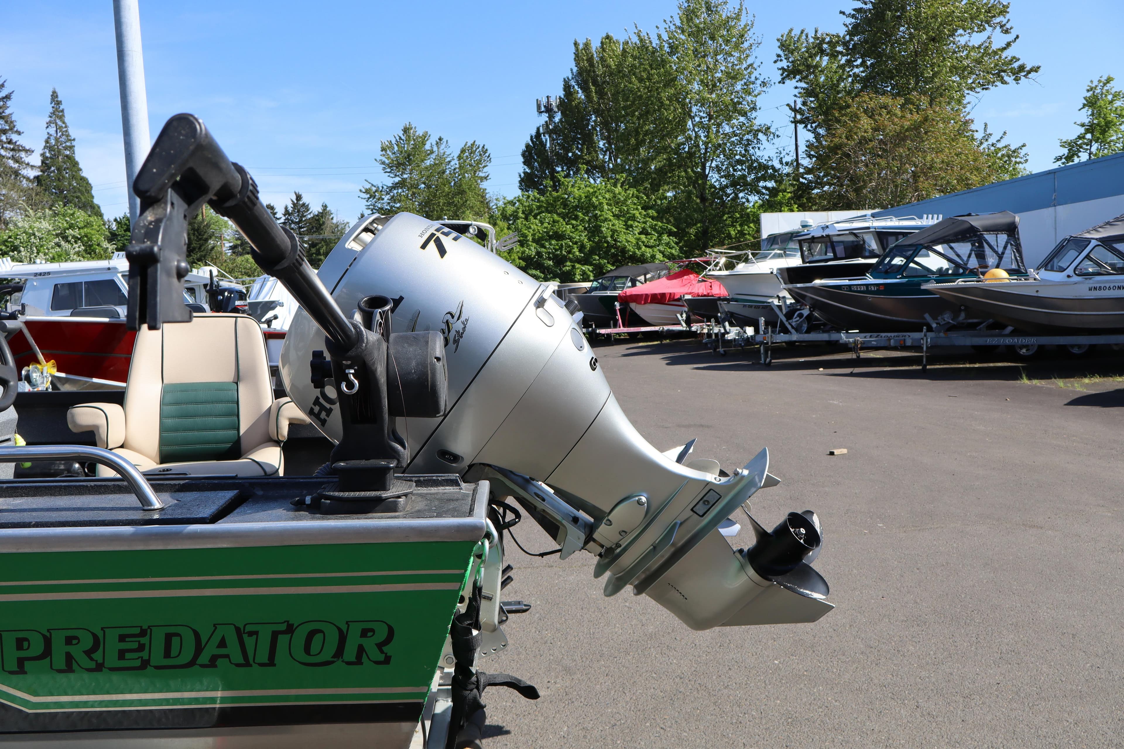 1997 Willie Boats Predator with outboard motor in a boatyard setting.