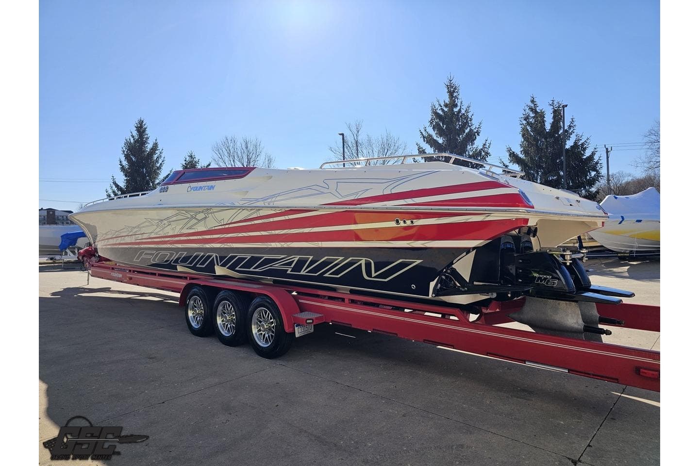 2009 Fountain 47 Lightning speedboat on red trailer, vibrant graphics, parked outdoors.