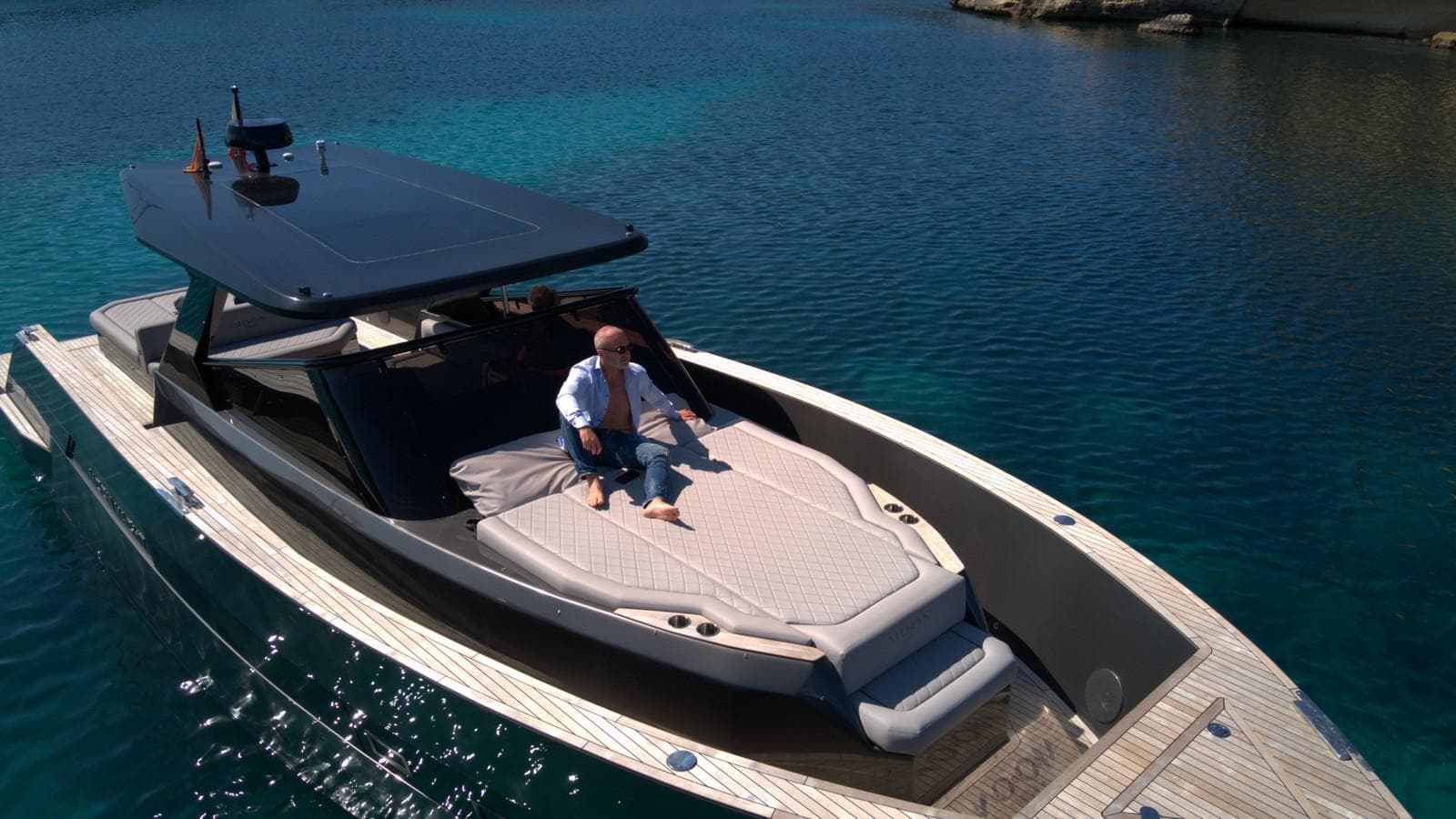 Luxury 2025 Moon 45 Sportsline yacht on clear blue water, featuring sleek design and sunbathing area.