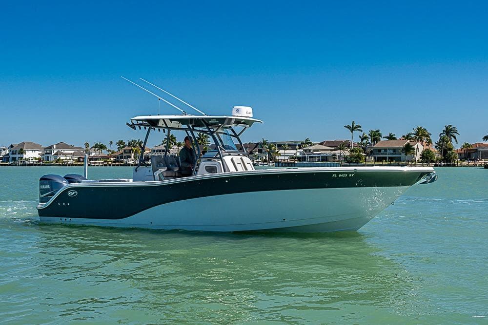 2018 Sea Fox 328 Commander boat cruising on calm waters near coastal homes.