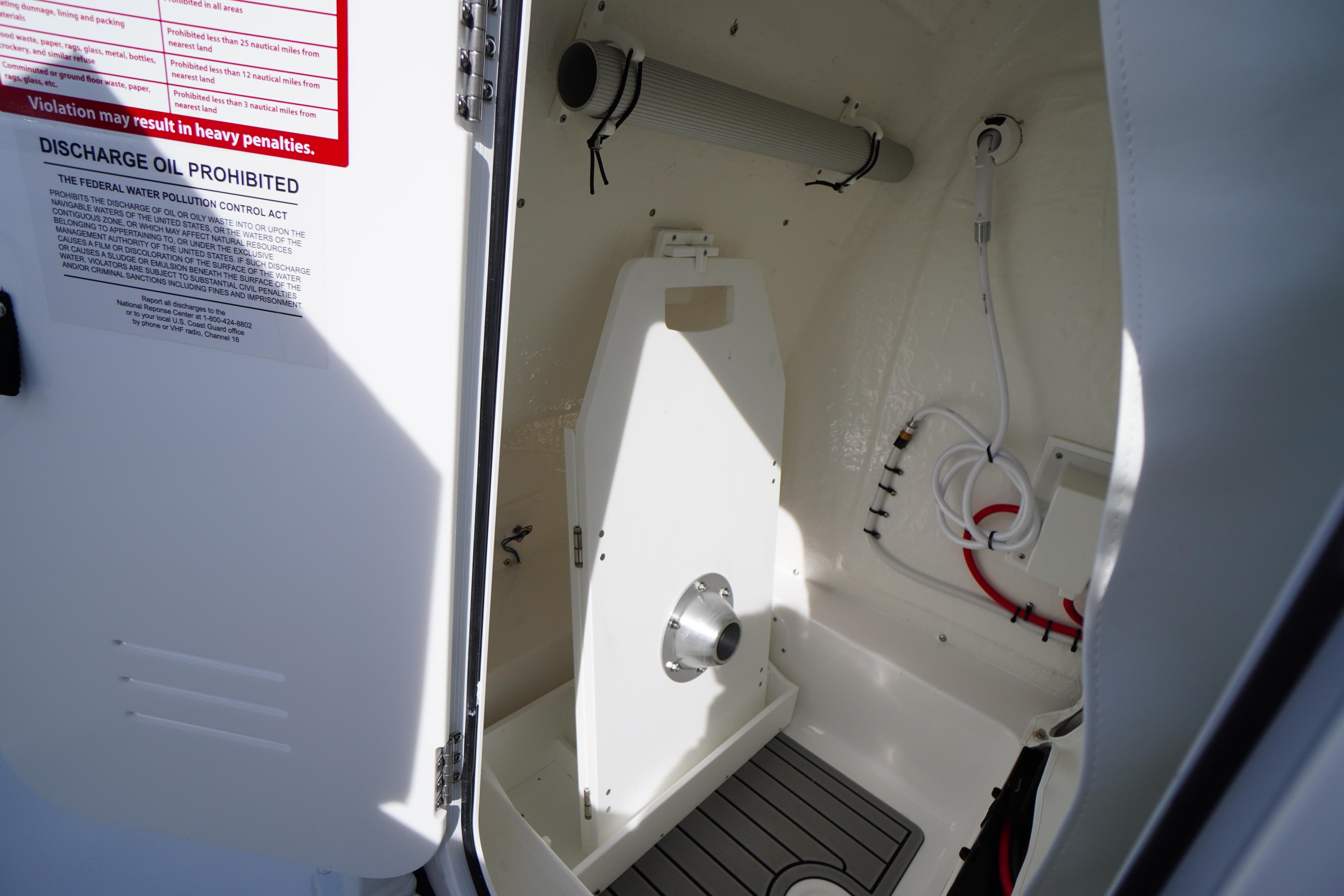 Interior view of 2026 Tidewater 220 LXF boat compartment with discharge warning.