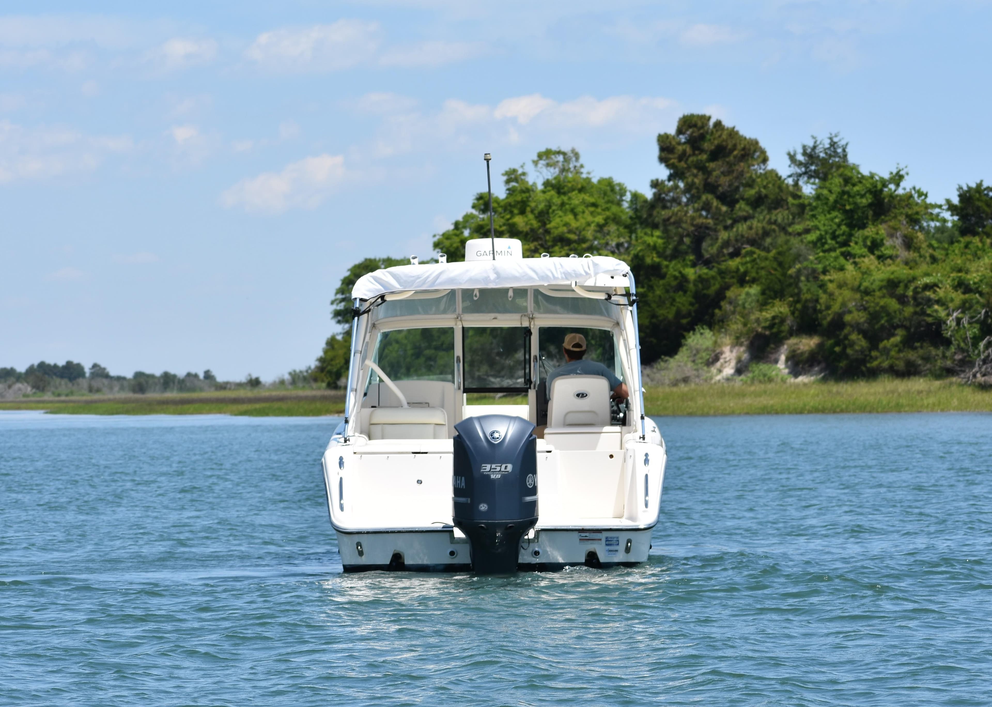 2012 Pursuit DC 265 Dual Console boat cruising on a serene lake.