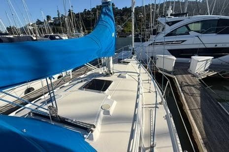 1985 Sabre 32 sailboat with blue sail cover docked at marina.