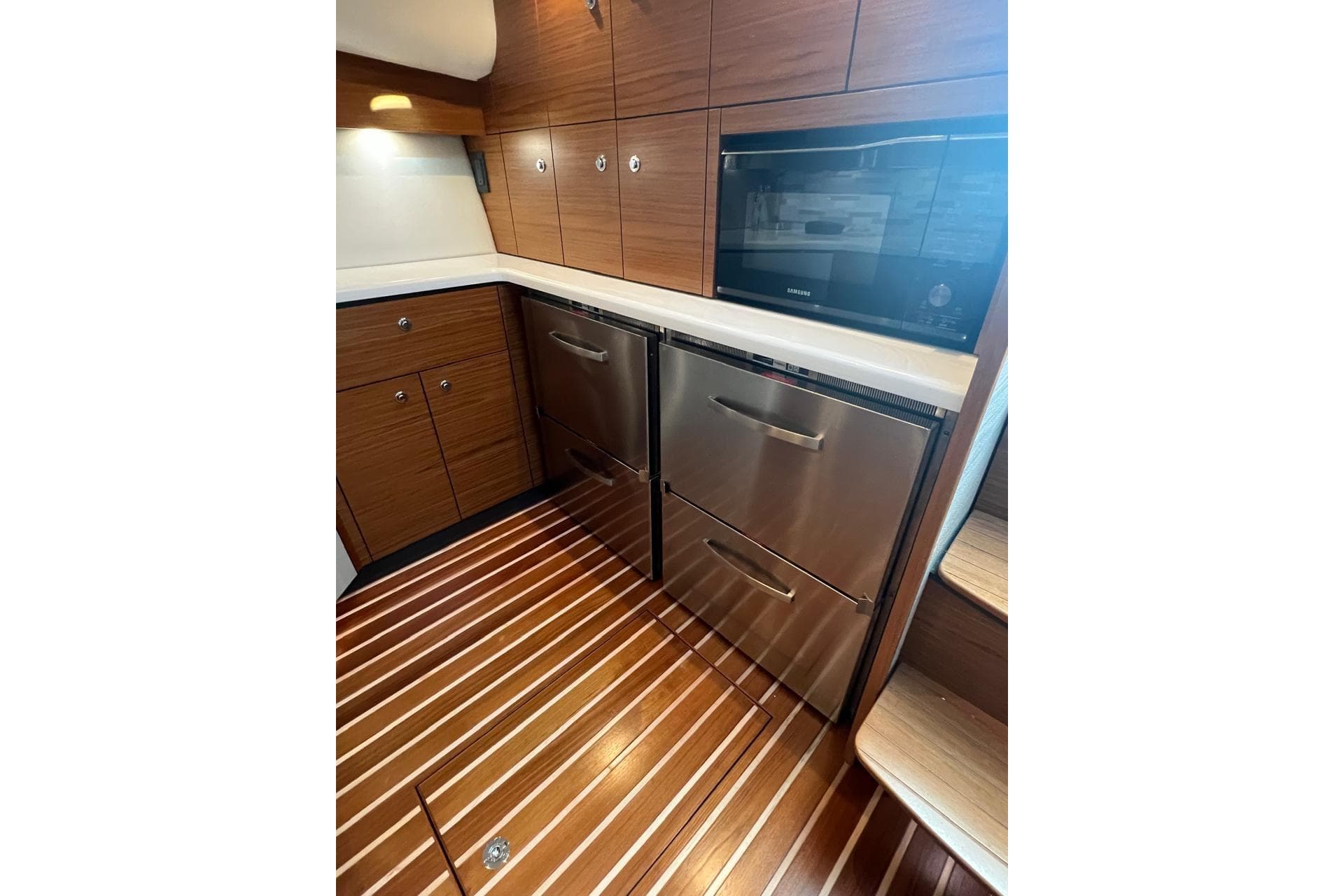 Luxurious galley in 2020 Tiara Yachts 43 Open, featuring wood cabinetry and stainless steel appliances.