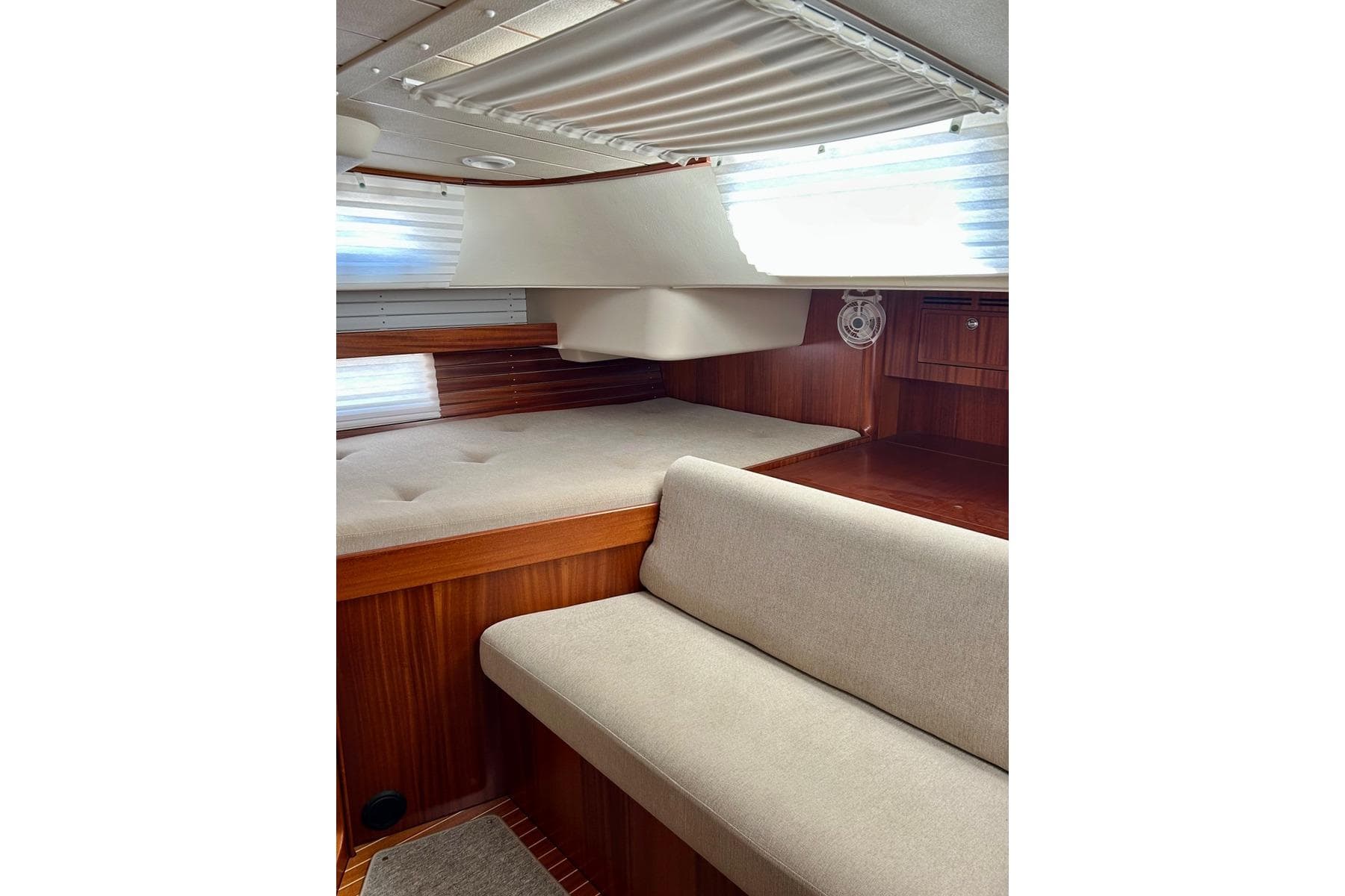 Interior of 2021 Hallberg-Rassy 44 yacht with wooden finish and beige upholstery.