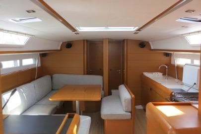 Interior of 2016 Jeanneau Sun Odyssey 519 yacht with modern seating and kitchen area.