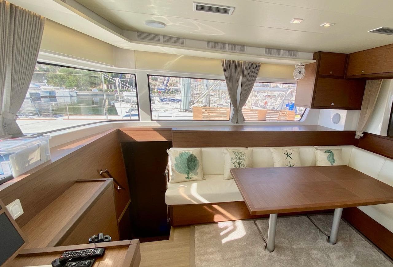 Interior of 2020 Lagoon 52 F yacht with modern seating and large windows.