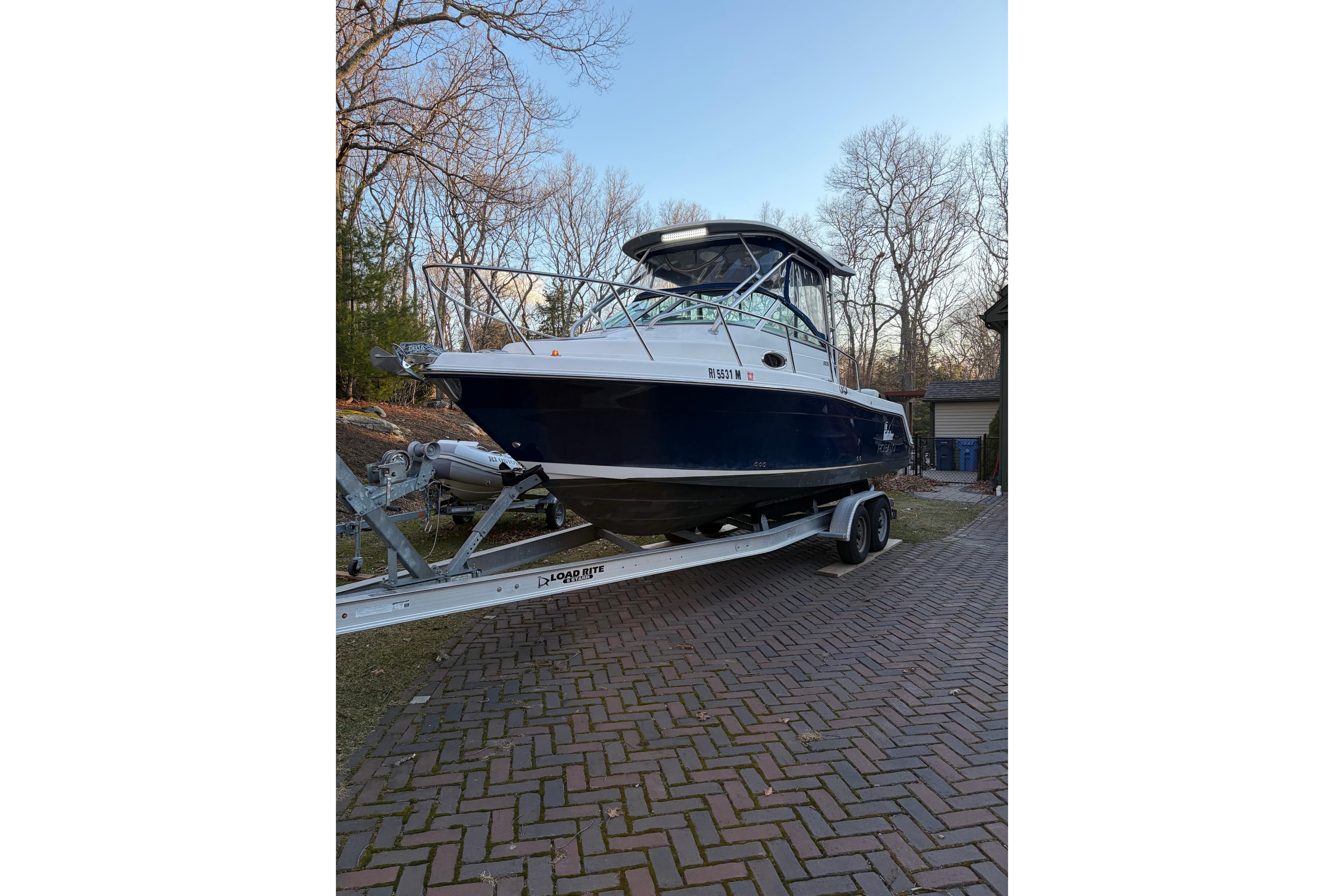 2014 Robalo R265 Walkaround boat on trailer, parked on brick driveway.