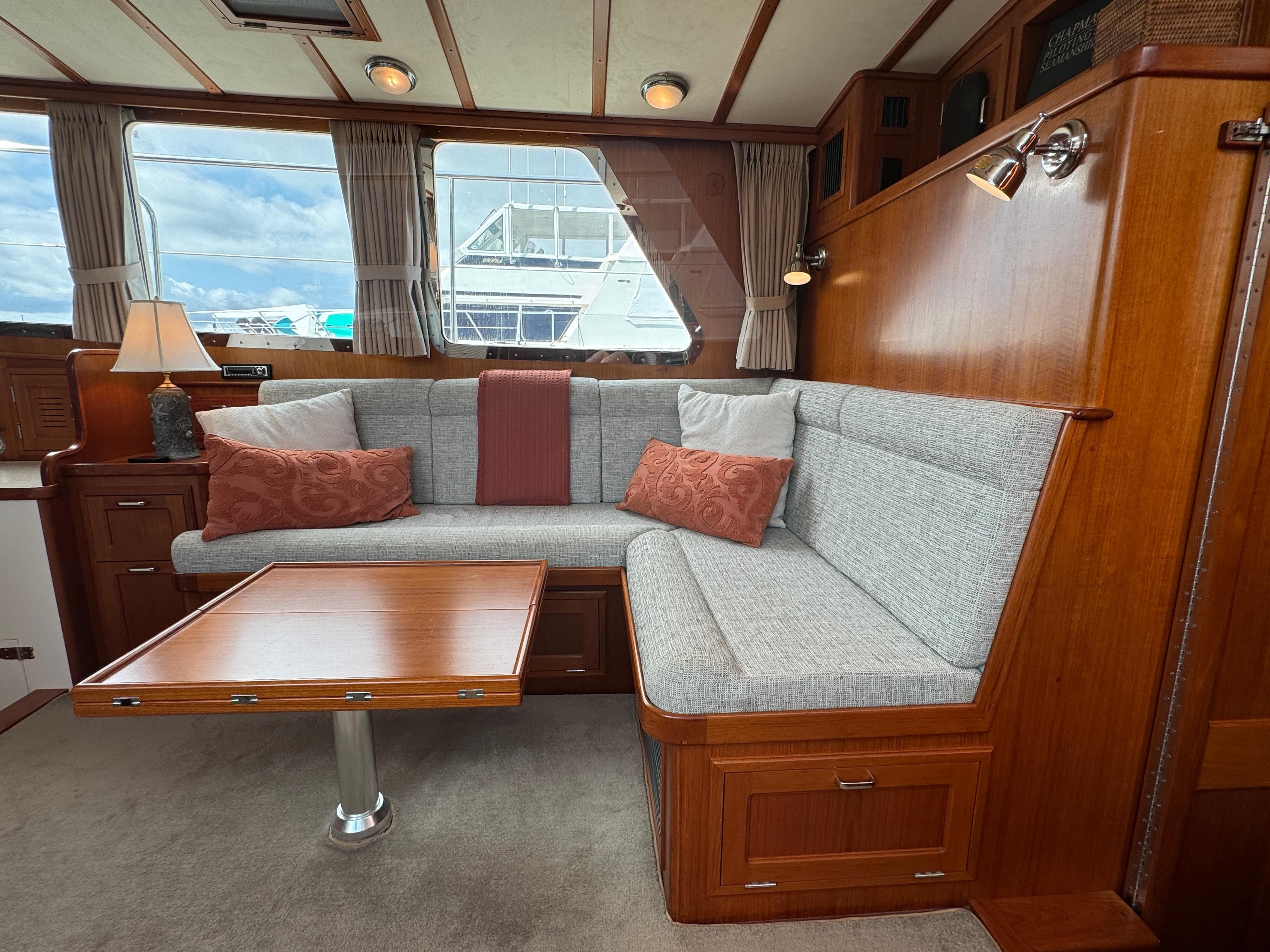 Interior of 2003 Dettling 51 Express Cruiser with cozy seating and wooden table.