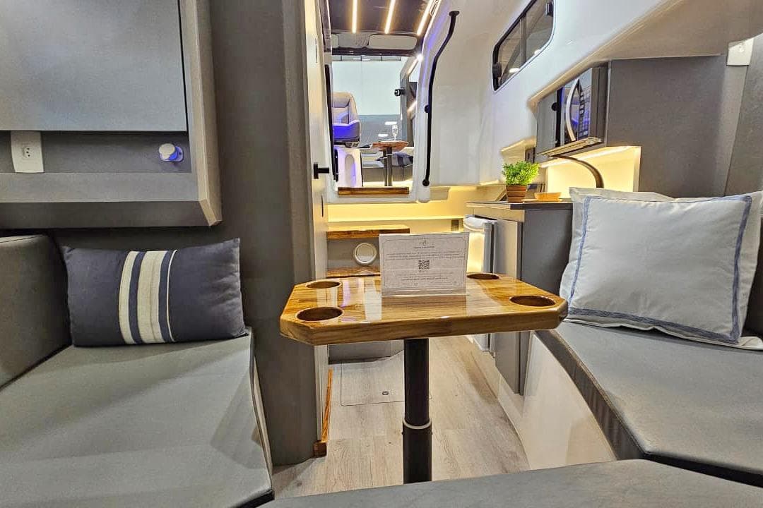 Modern interior of 2026 Hanover 327 RV with cozy seating and wooden table.