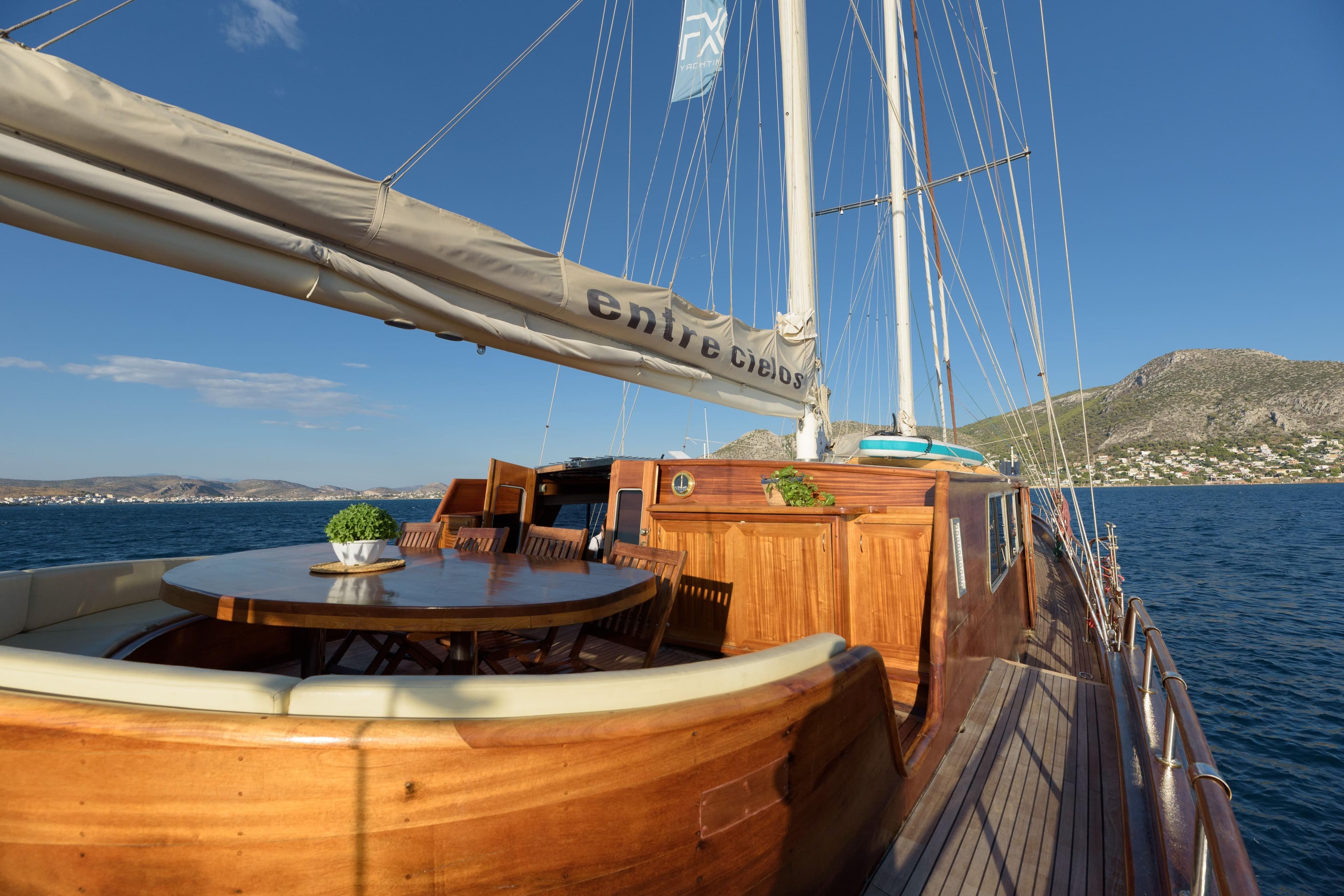 Luxurious 2004 Su Marine Gulet yacht with wooden deck, dining area, and scenic ocean view.