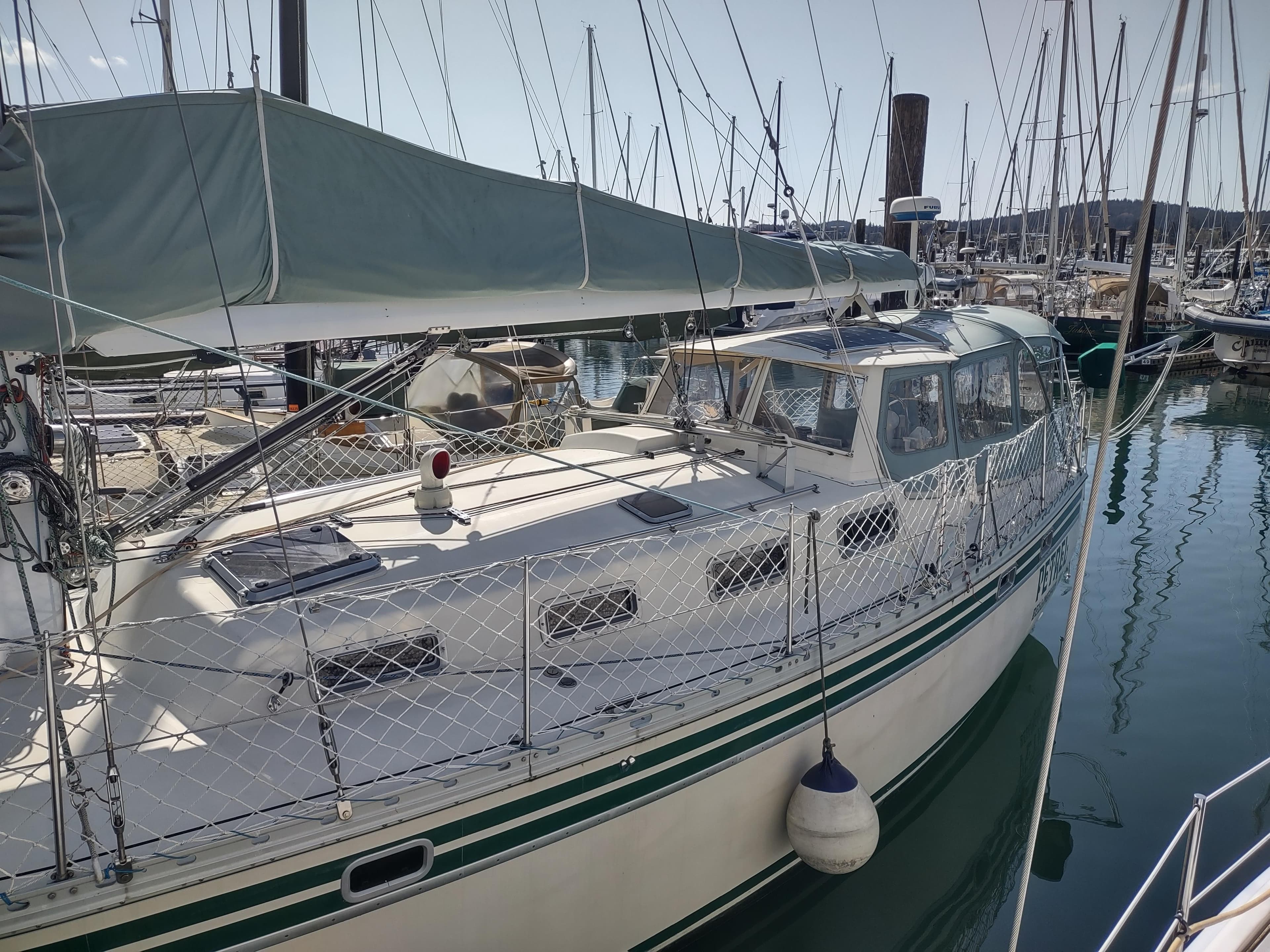 Sailboat docked in marina, Cascade 42 model, 1988, with green trim and canopy.