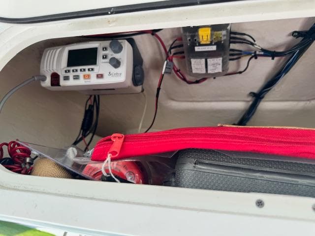 2013 Sea Fox 286 CC storage compartment with electronic equipment and red zippered bag.