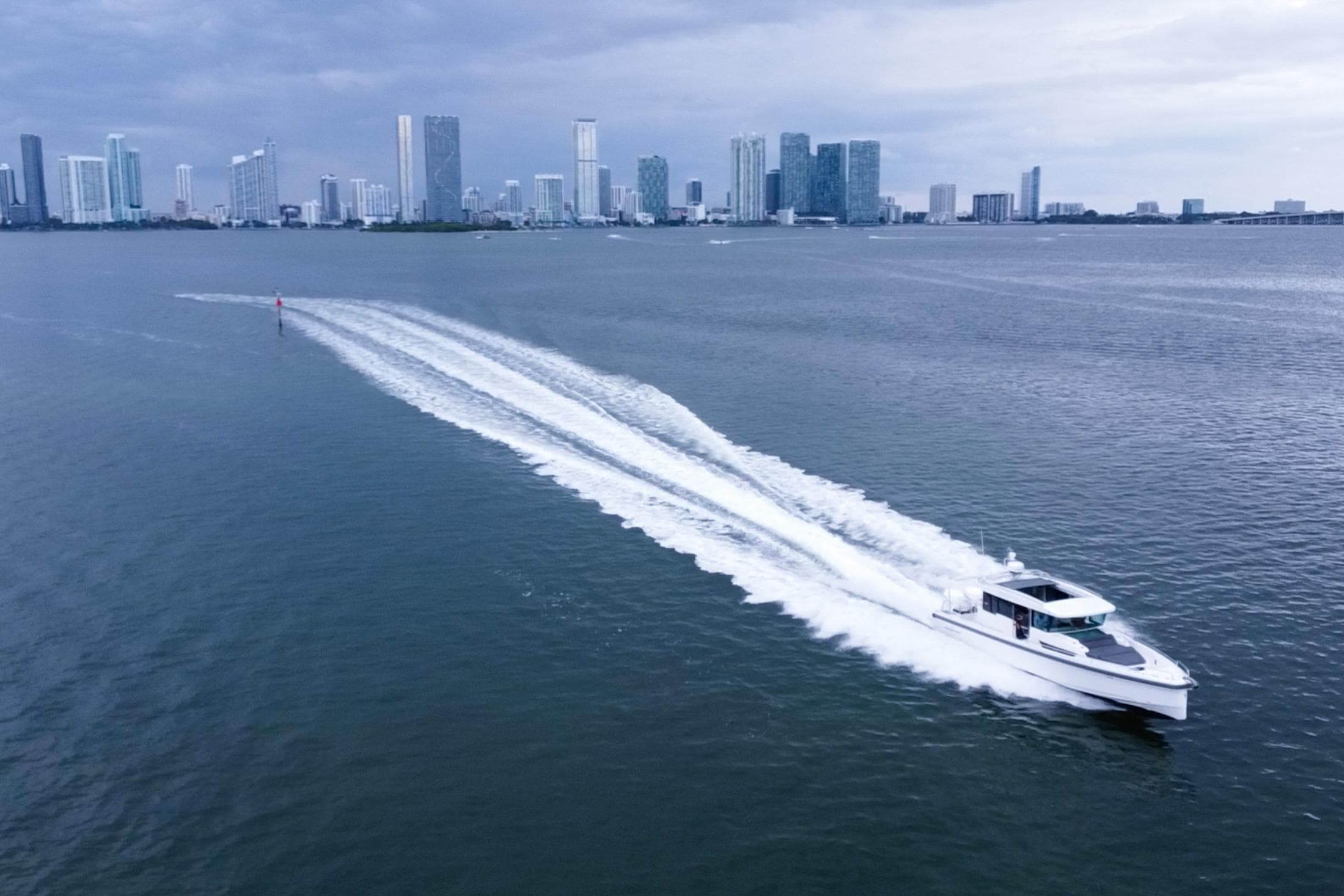 Axopar 37 XC Cross Cabin 2020 cruising on water with city skyline backdrop.