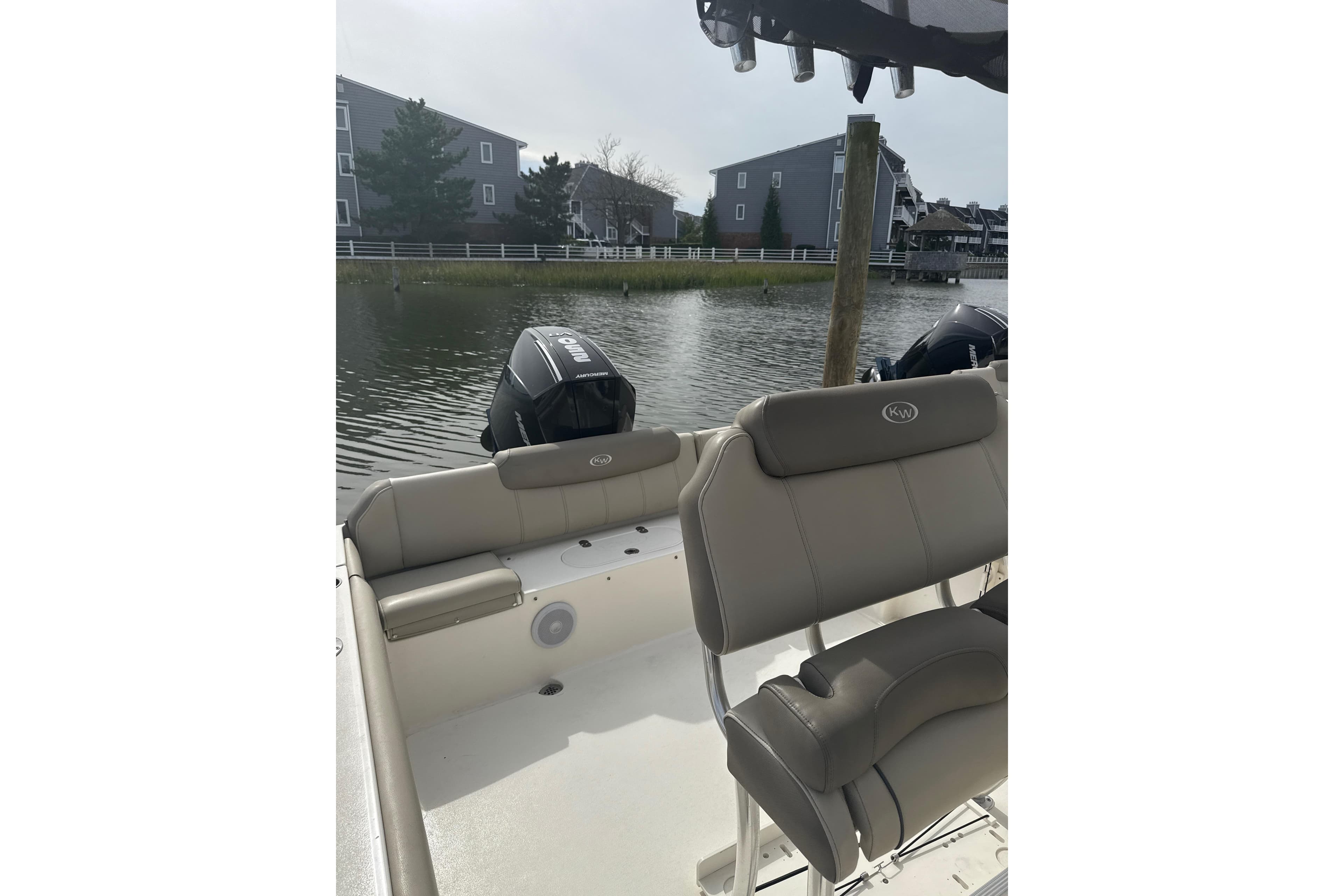 2024 Key West 239 FS boat interior with seating and outboard motors by the water.