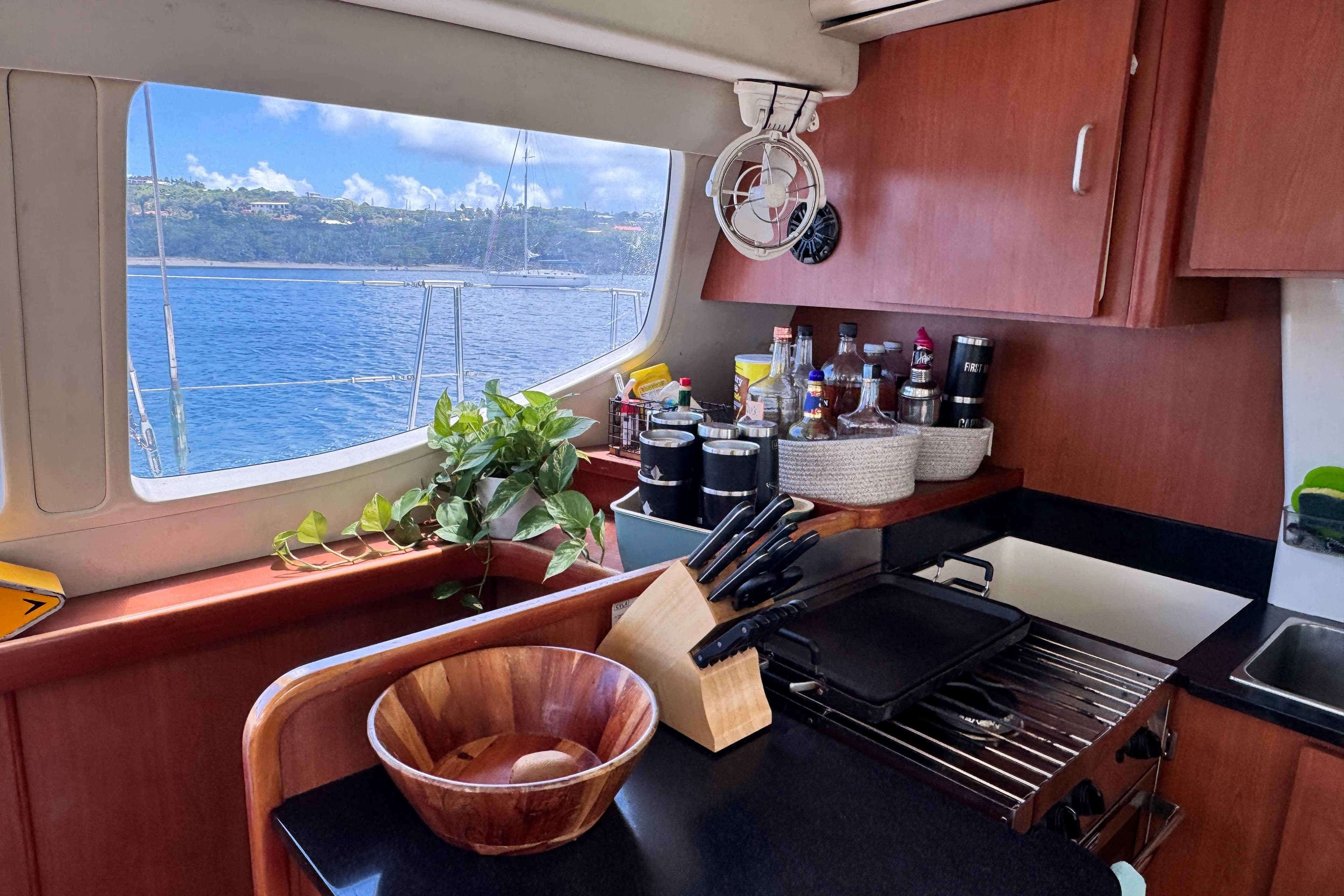 Luxurious Leopard 46 yacht kitchen with ocean view, featuring wooden cabinetry and modern appliances.