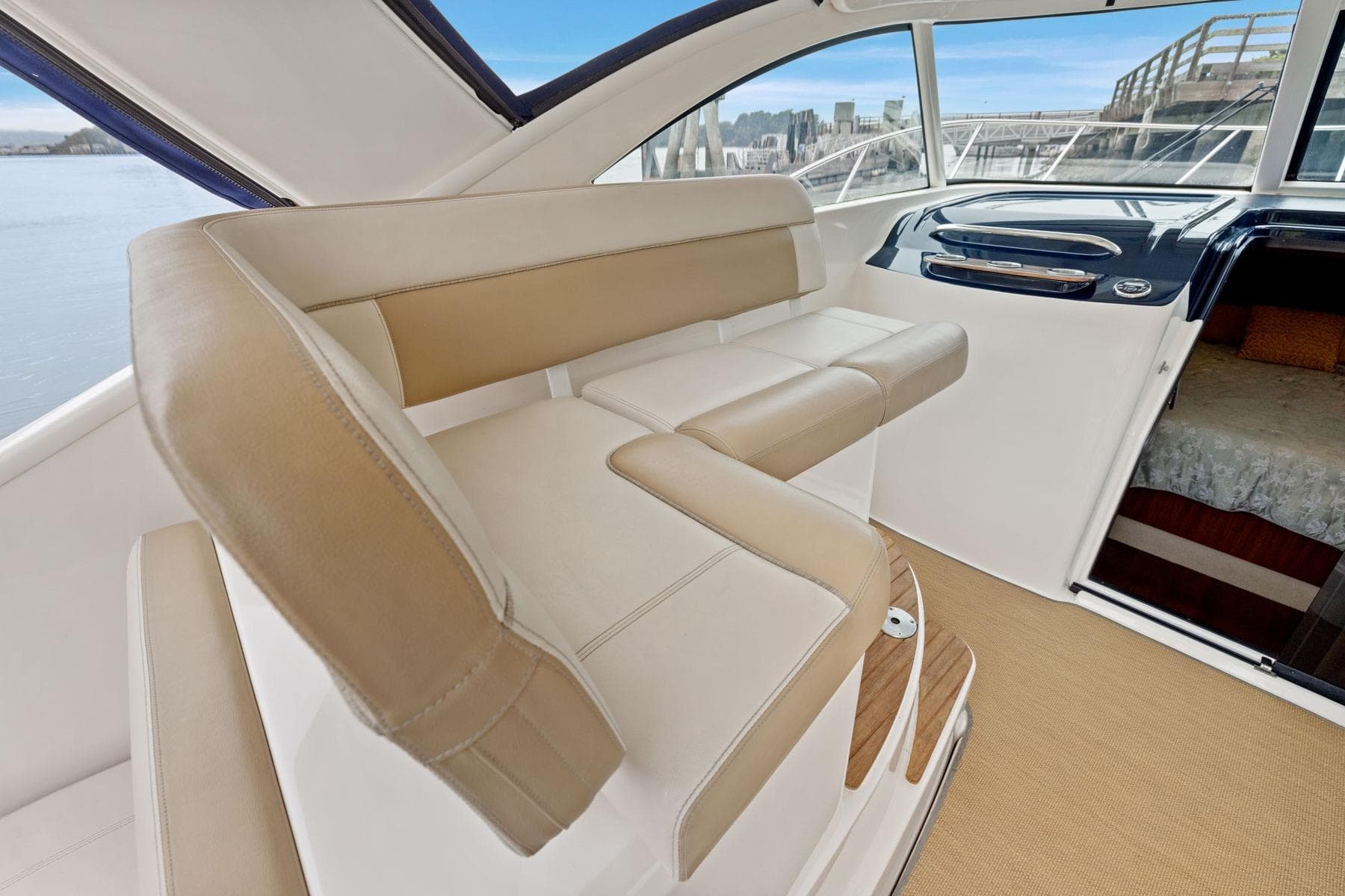 Interior of 2012 Tiara Yachts 3100 Coronet, featuring beige seating and helm area.