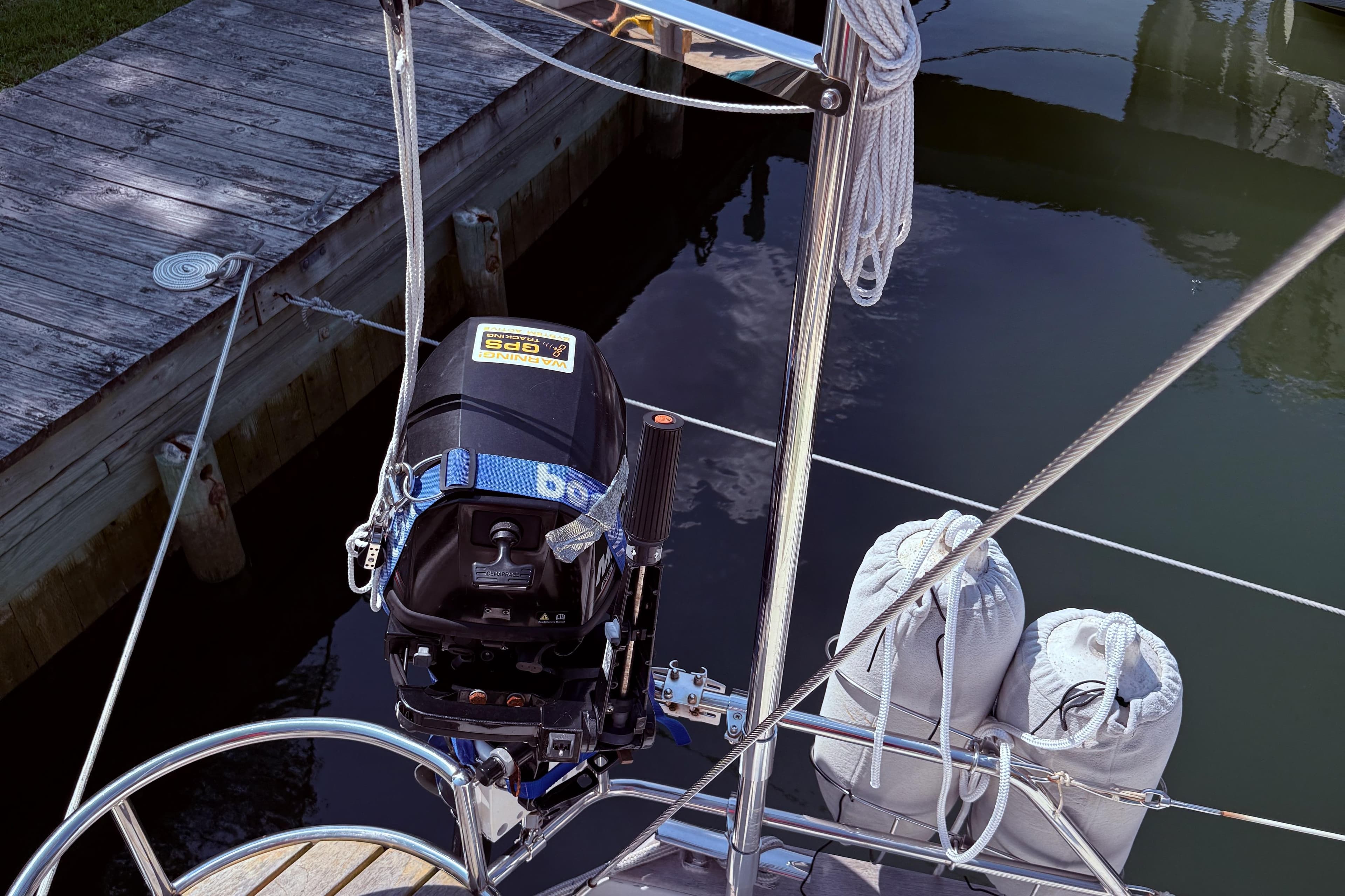 Outboard motor on a 2006 Southerly 115 Mk IV sailboat docked by wooden pier.