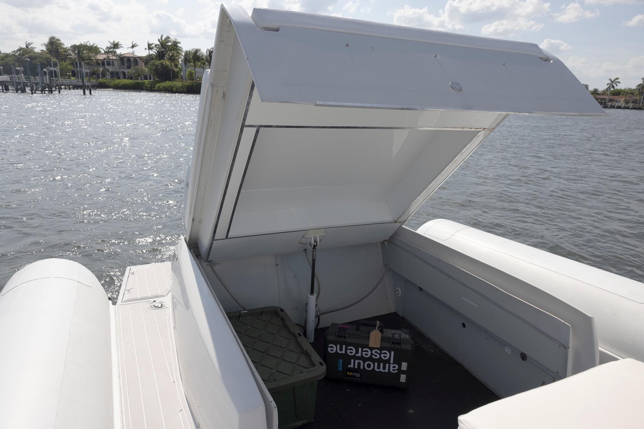 Open storage compartment on 2013 Zeta Elle 34 Custom boat by the water.