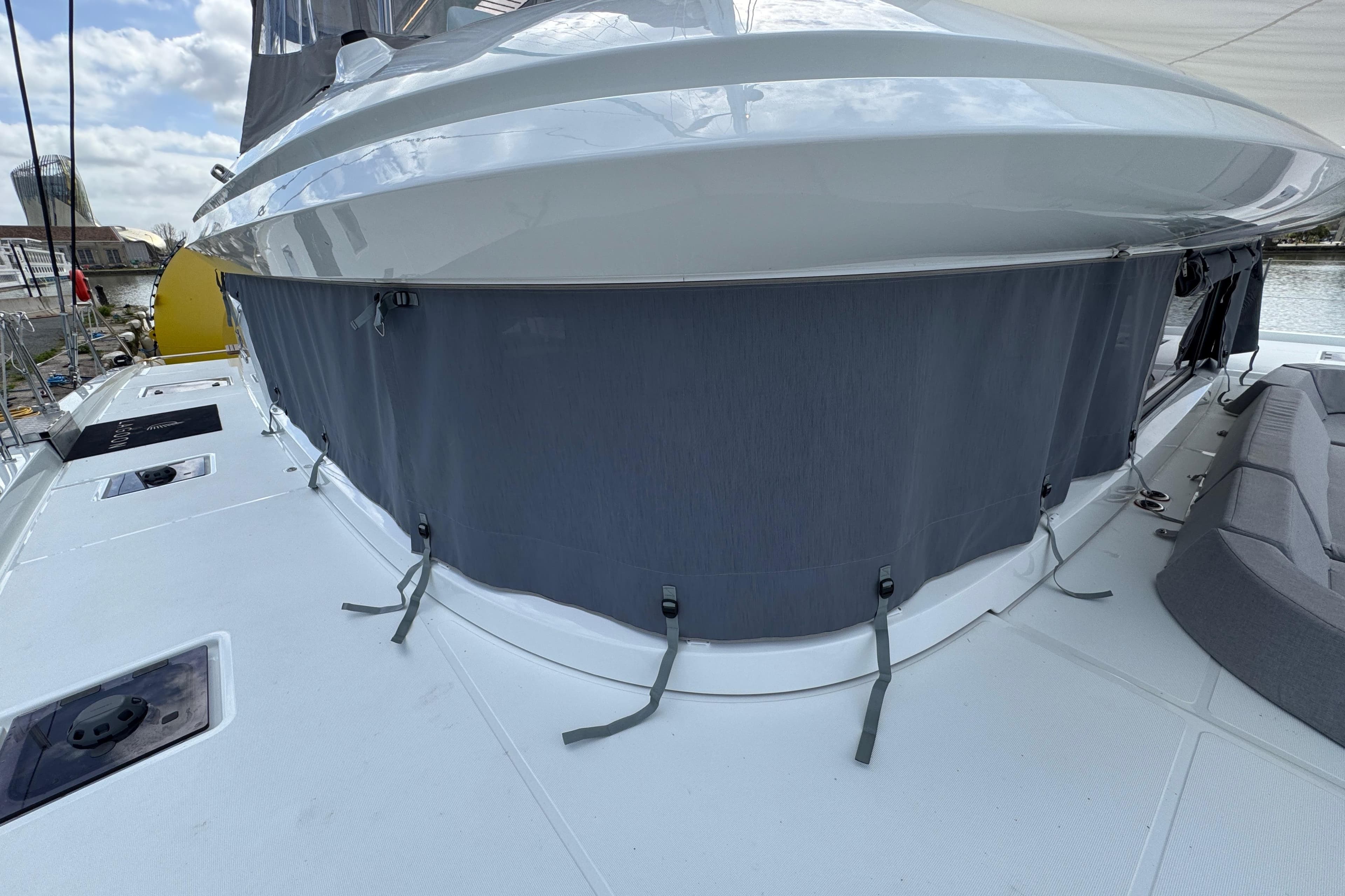 2026 Lagoon 55 yacht deck with gray canvas cover and seating area.