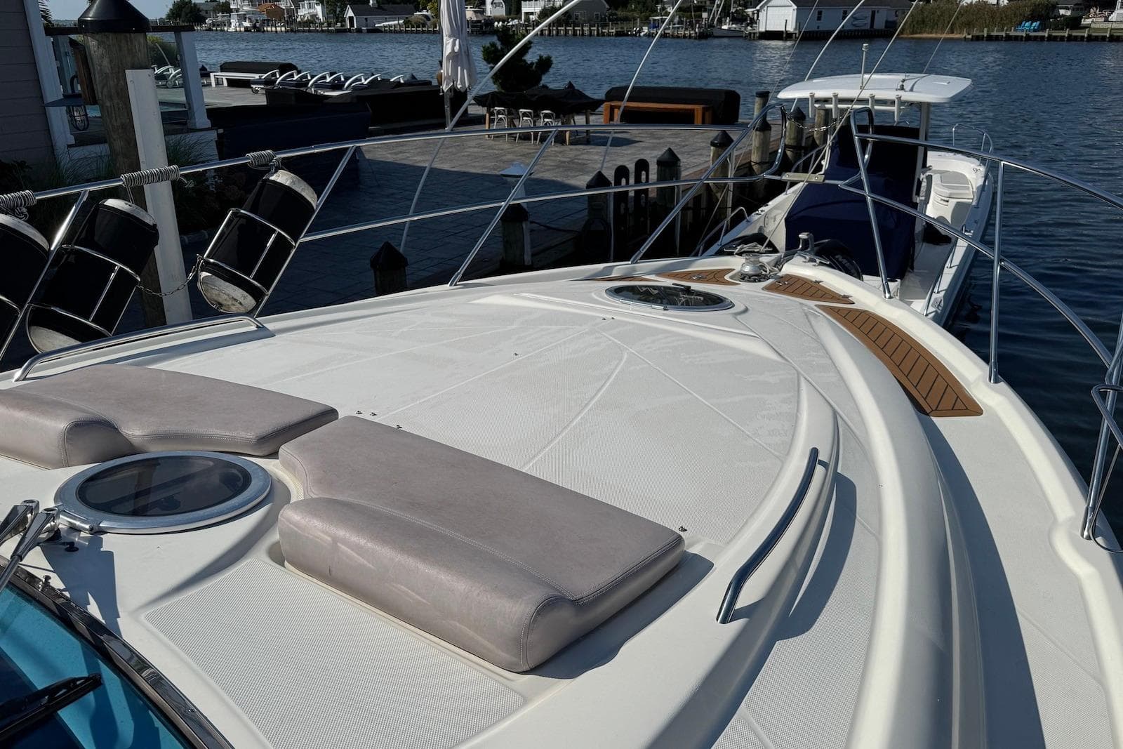 2009 Cranchi Mediterranee 43 yacht deck with sun pads, docked by the water.