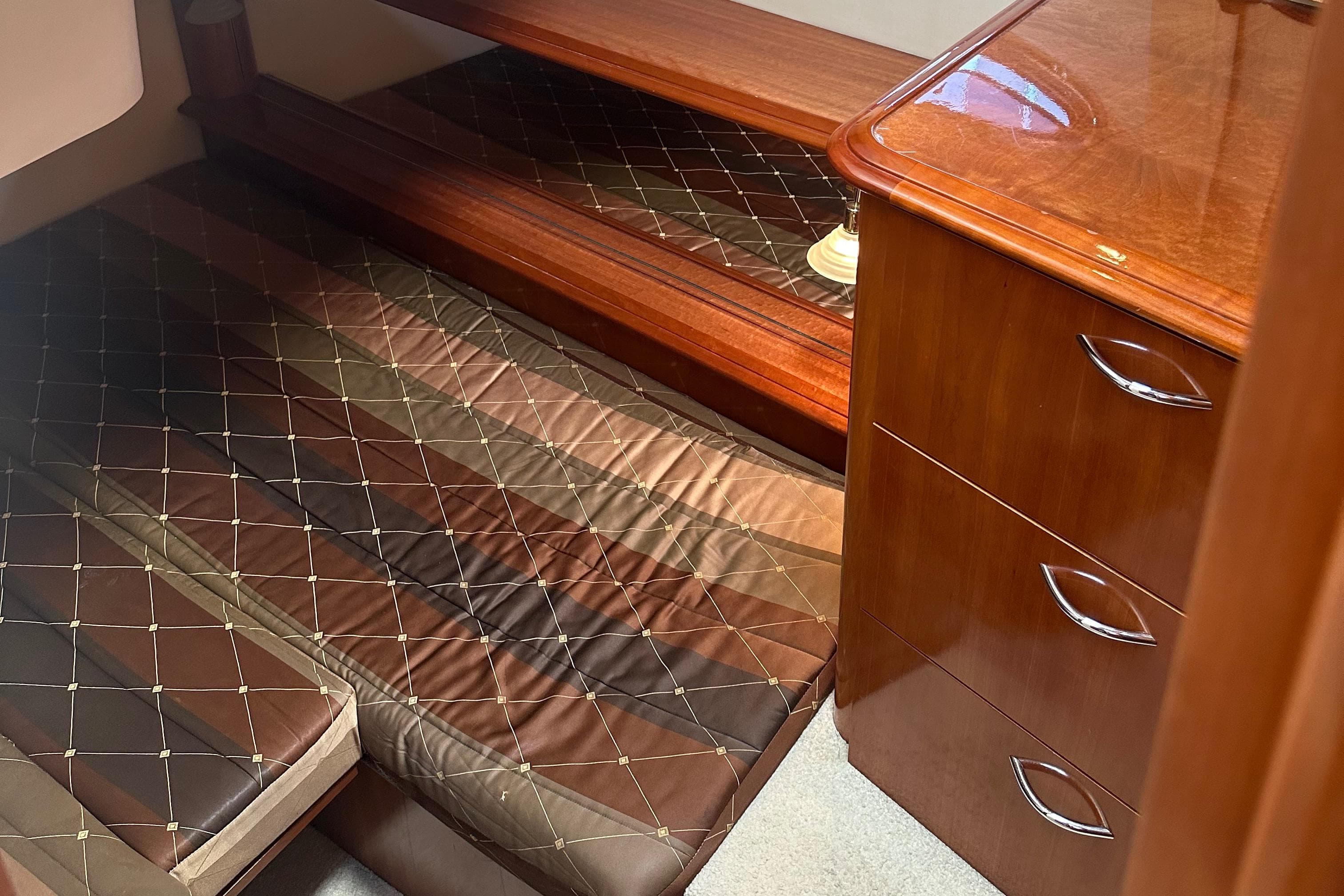2004 Carver 420 Mariner cabin with wooden furniture and quilted bedding.