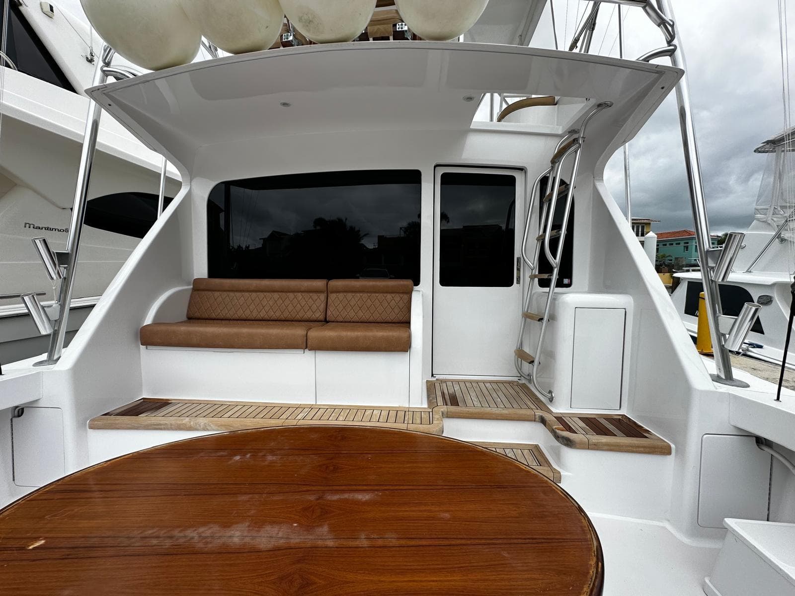 2003 Viking 52 yacht cockpit with seating, wooden table, and ladder.