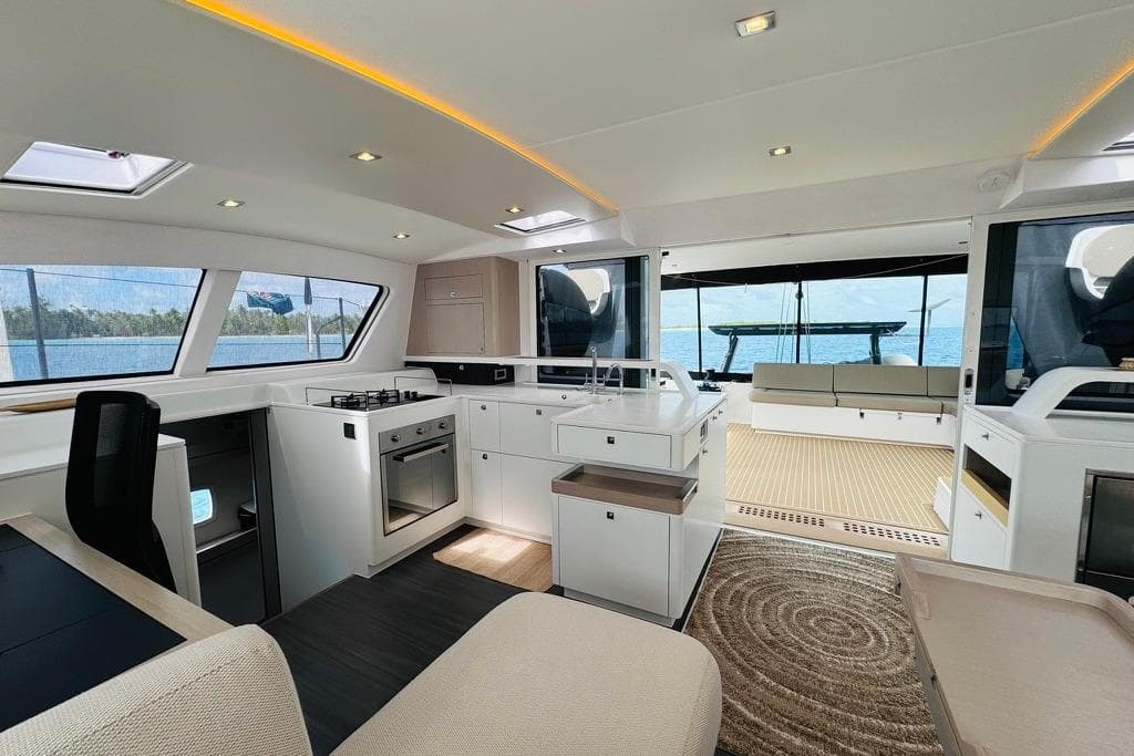 Luxurious interior of 2021 Outremer 59.2 yacht with modern kitchen and spacious seating area.