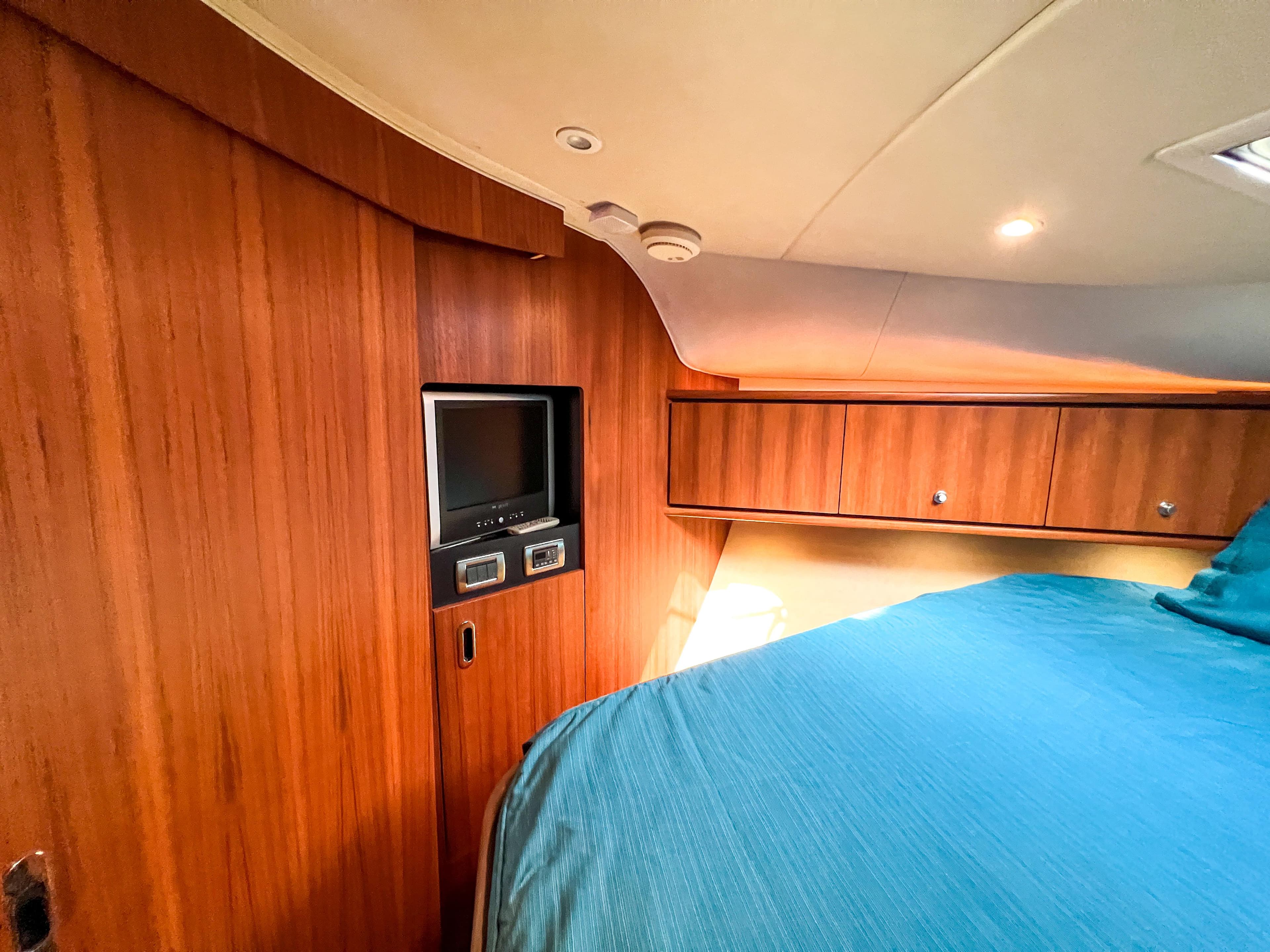 2008 Tiara Yachts 3900 Sovran cabin with wood paneling and cozy bed.